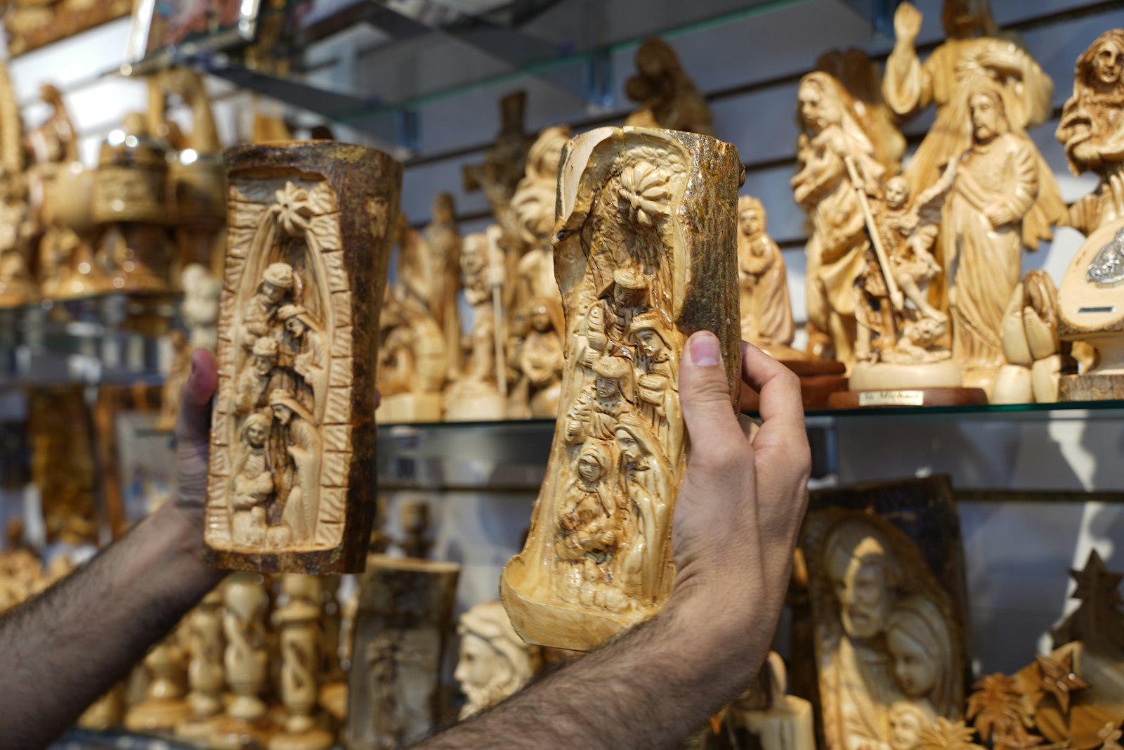 Khair holds two carvings of the Magi visiting the Holy Family at the Nativity. Each piece at Jerusalem Arts is unique as they are all hand-carved, with olive wood that has been treated for six months before carving, so each cut of wood has a different texture and color.