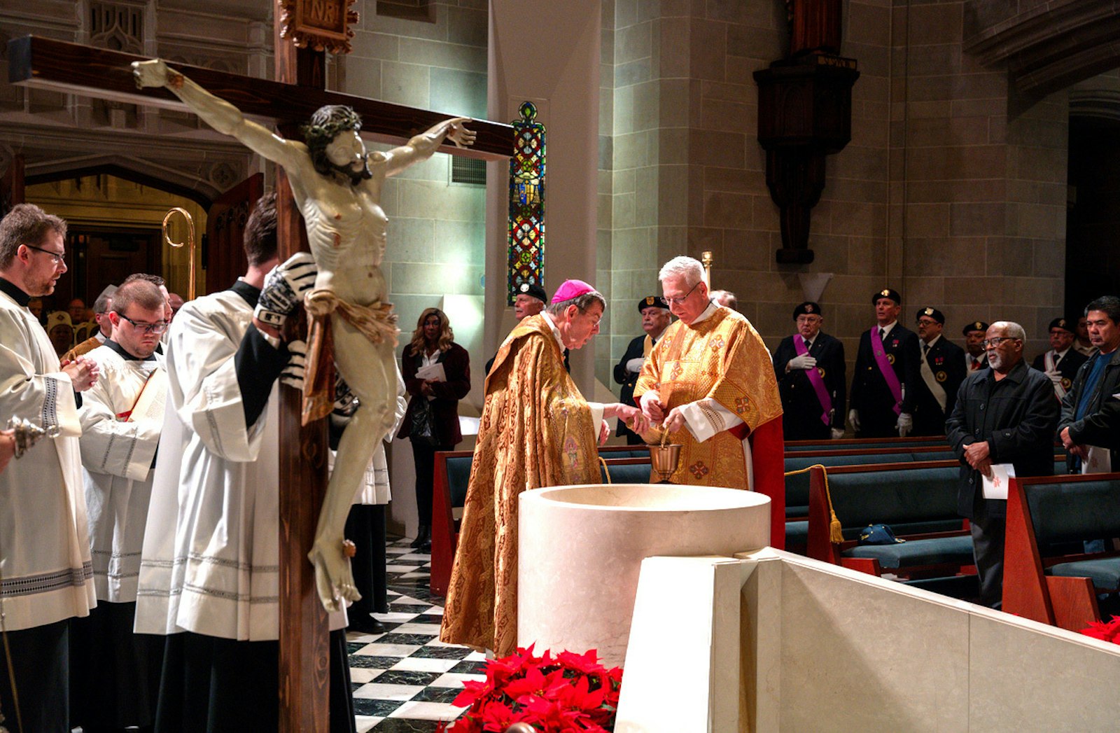 Archbishop Vigneron prepares to bless the congregation as an altar server carries in a large crucifix that will be kept at the Cathedral of the Most Blessed Sacrament, one of 12 designated pilgrimage sites in the Archdiocese of Detroit during the jubilee year.