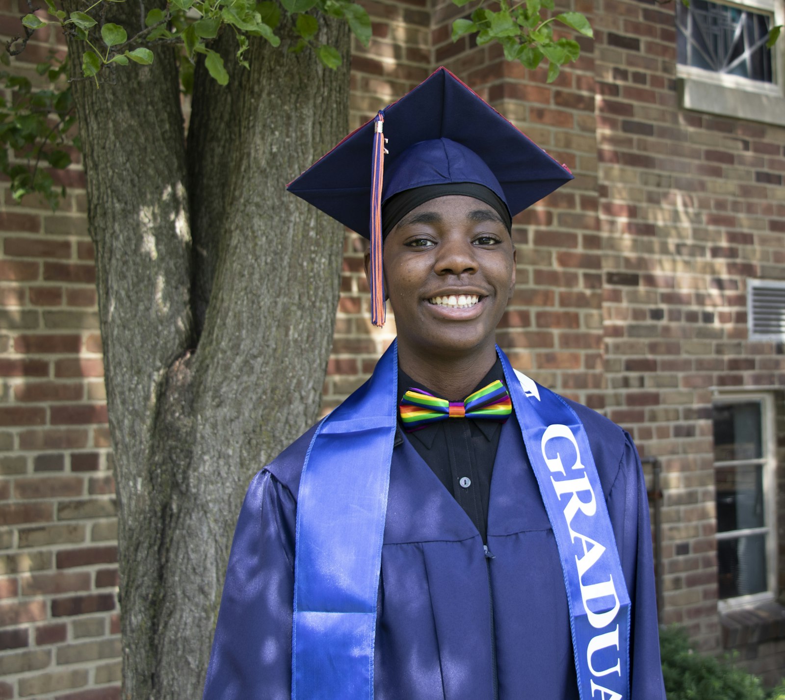 A 2022 graduate from Clara B. Ford Academy smiles in cap and gown. Vista Maria's motto is, “One person is of greater value than the world.”