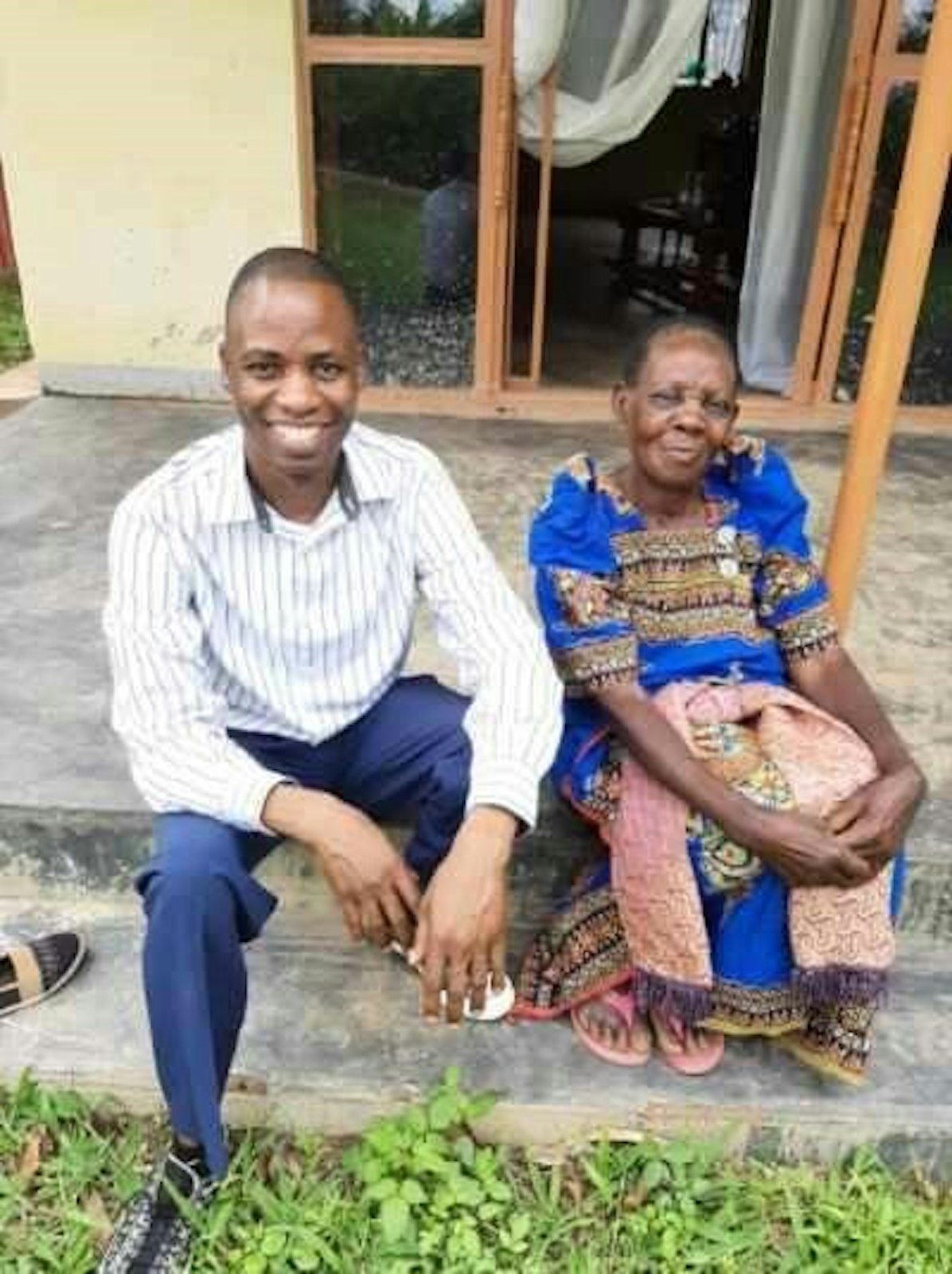 Joseph Kirembwe disfruta de una esperada visita con su madre, Cotilda Nakamatte, en la casa familiar de Uganda. (Cortesía de Joseph Kirembwe)