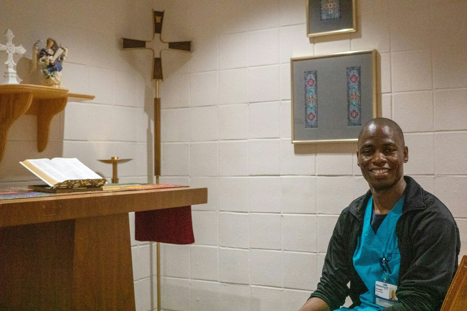 Joseph Kirembwe, de 36 años, se detiene en la capilla para rezar antes de su turno. Kirembwe dice que su fe católica le ayuda a ser un mejor cuidador, y le encanta compartir su fe con los demás. (Matthew Rich | Especial para Detroit Catholic)