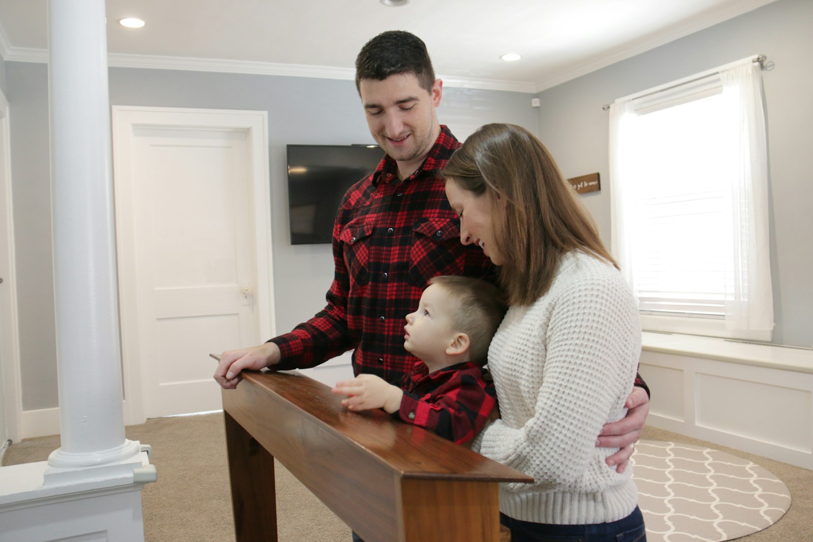 Joe and Alexandria Staniszewski with their son, John Paul, on the Communion kneeler Joe built for the couple's wedding. Joe built a similar kneeler for St. Mary Parish in Royal Oak.