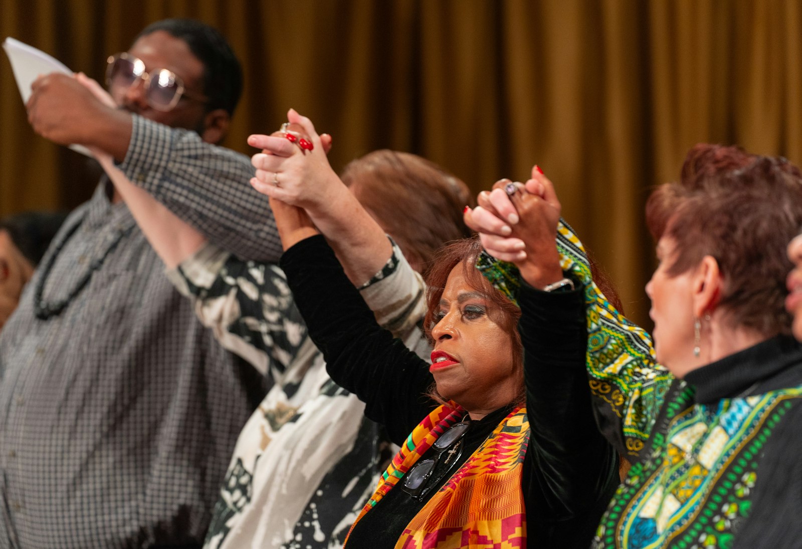 Choir members lift their hands in praise during the Mass for Justice and Peace. About 150 people, including members of the Knights and Ladies of Peter Claver, took part in the annual celebration.