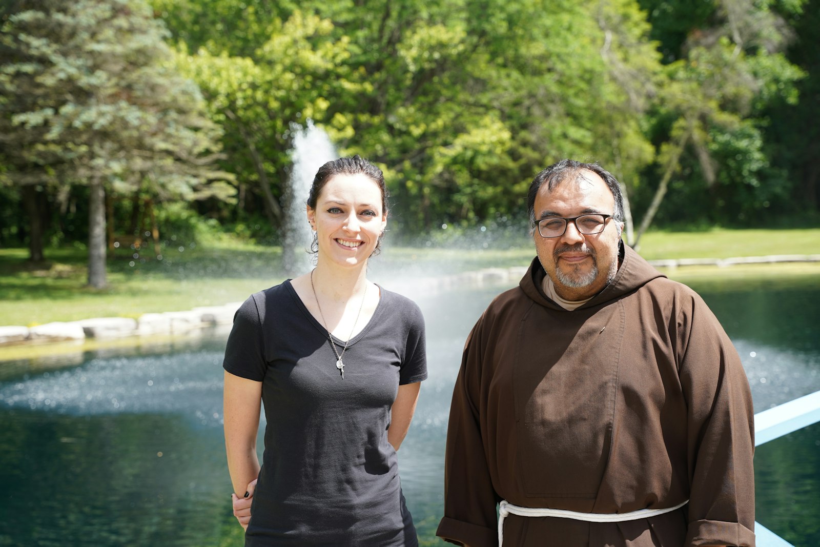 El P. Dudek y el P. Martínez de pie en medio de los terrenos del Capuchin Retreat Center en Washington Township. Ambos sienten que la nueva estatua de San Francisco llevará a la gente a entregar sus dolores y luchas a la cruz.