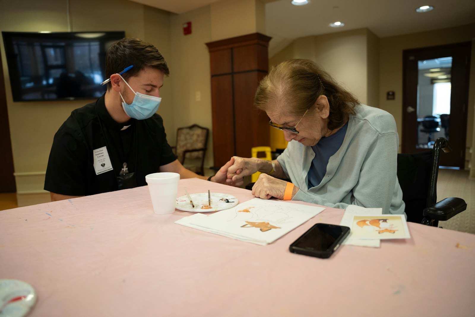 Matthew Conner, a seminarian studying for the Companions of the Cross, prays with a resident at Marywood Nursing Care Center in Livonia on Jan. 28.