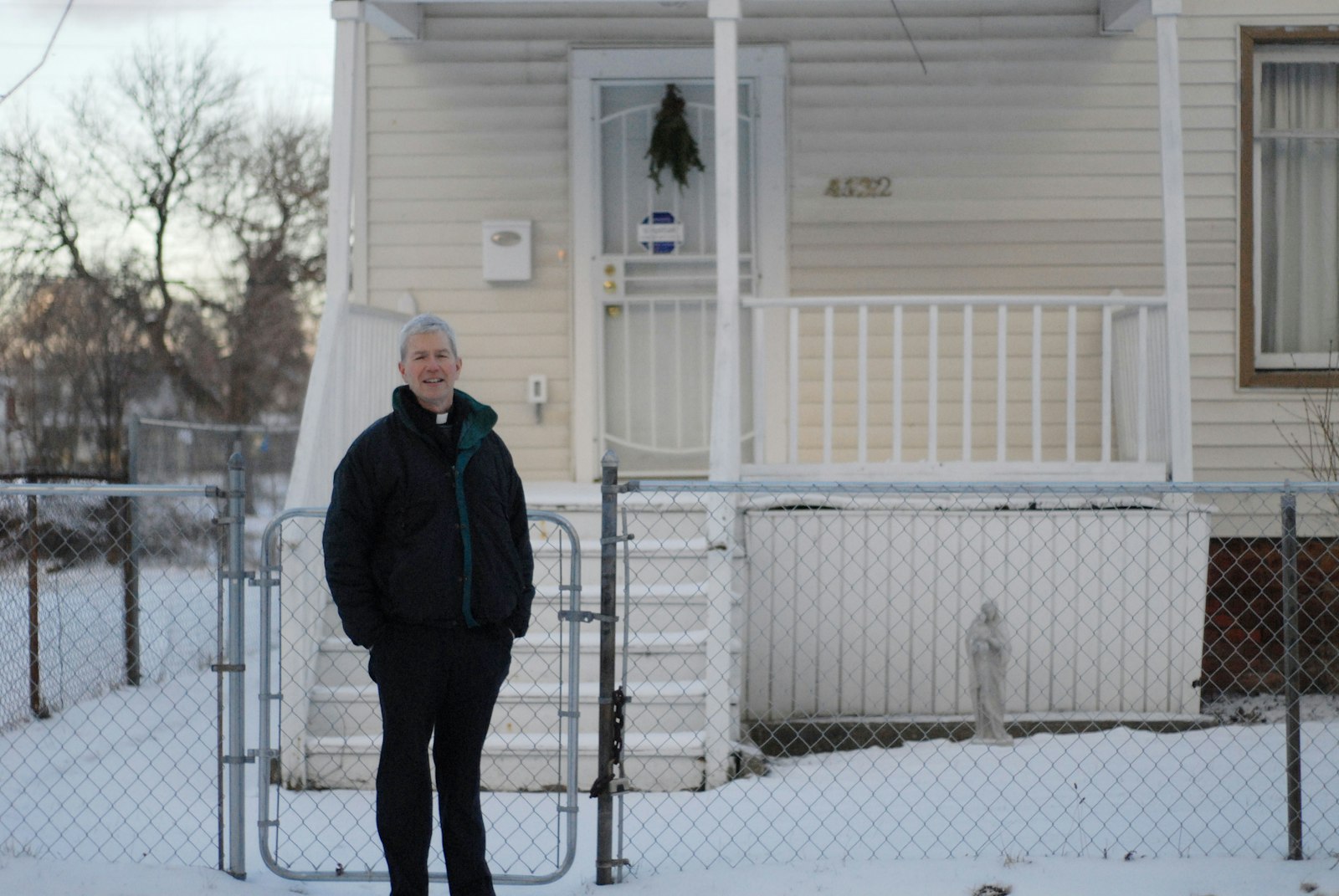 Msgr. Trapp stands in front of a house he purchased near St. Augustine and St. Monica Parish with the help of a nonprofit he formed to refurbish the neighborhood and fix up homes for those in need of low-income housing in this 2016 photo. (Michael Stechschulte | Detroit Catholic)
