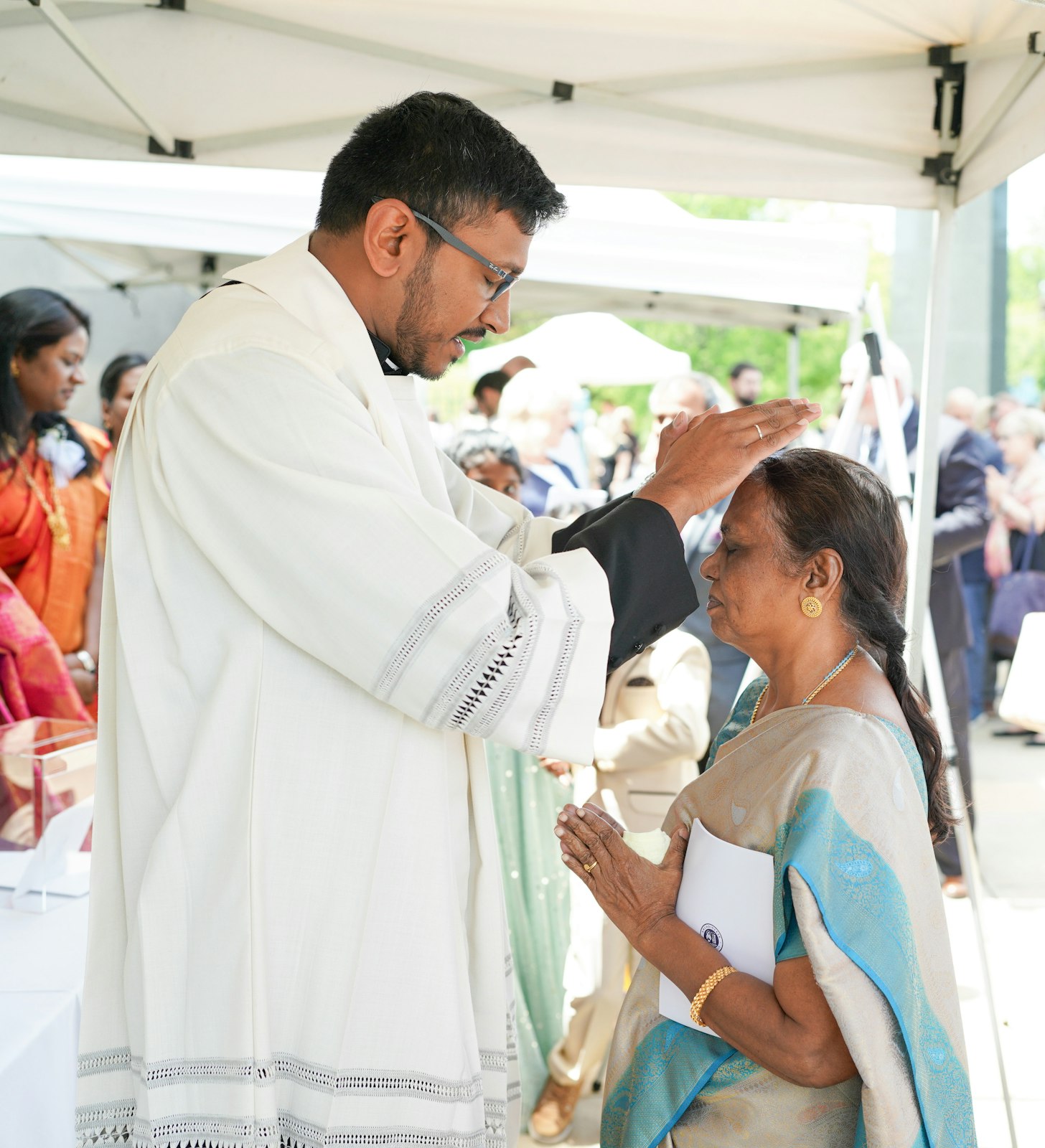 Fr. Michael Selvaraj blesses his aunt, who traveled to be present at the cathedral from her home in India, following Fr. Selvaraj's ordination to the priesthood May 27.