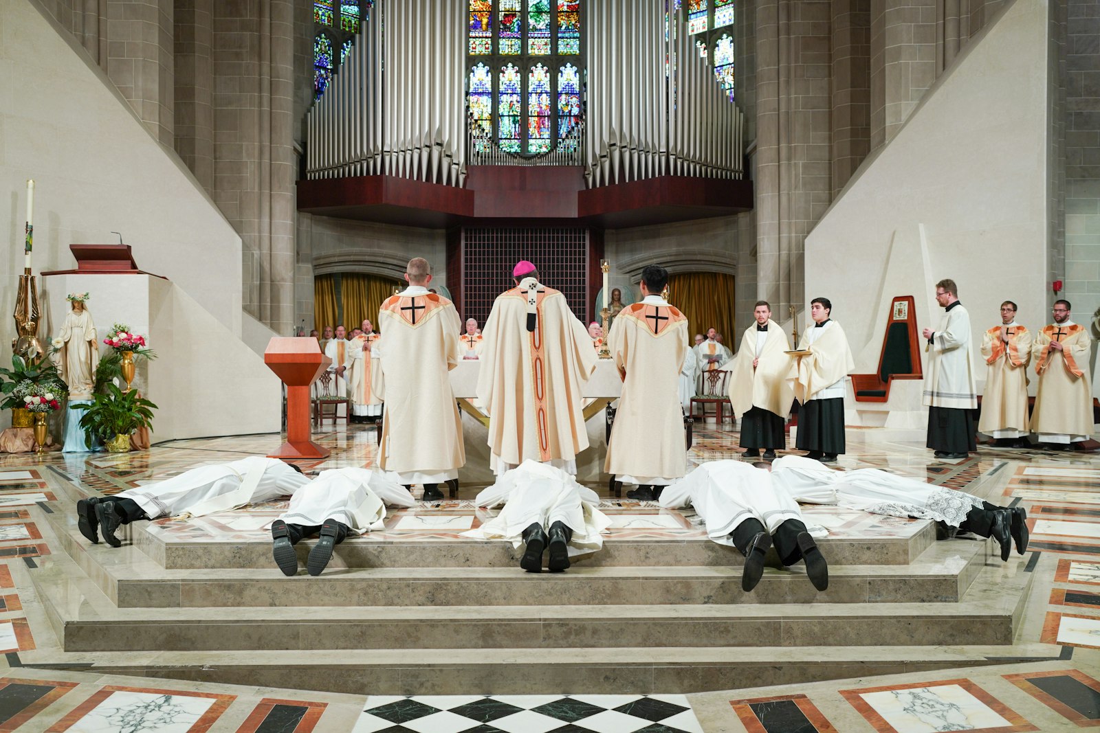 The five met set to be ordained priests lie prostrate during the Litany of Supplication. Archbishop Vigneron told the men during his homily their mission has been set for them since before they were born.