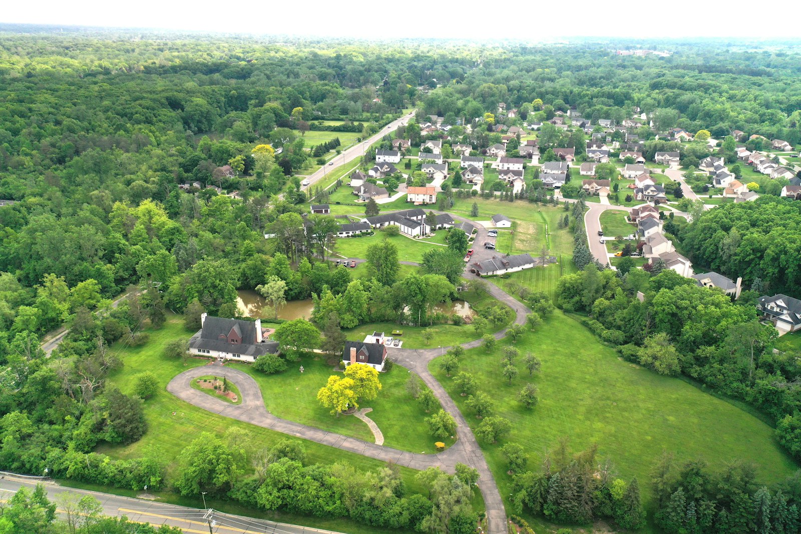 A drone view captures an aerial view of the new PIME U.S. Mission Center in Farmington Hills, including 12 serene acres featuring wildlife and open spaces for walking and prayer.