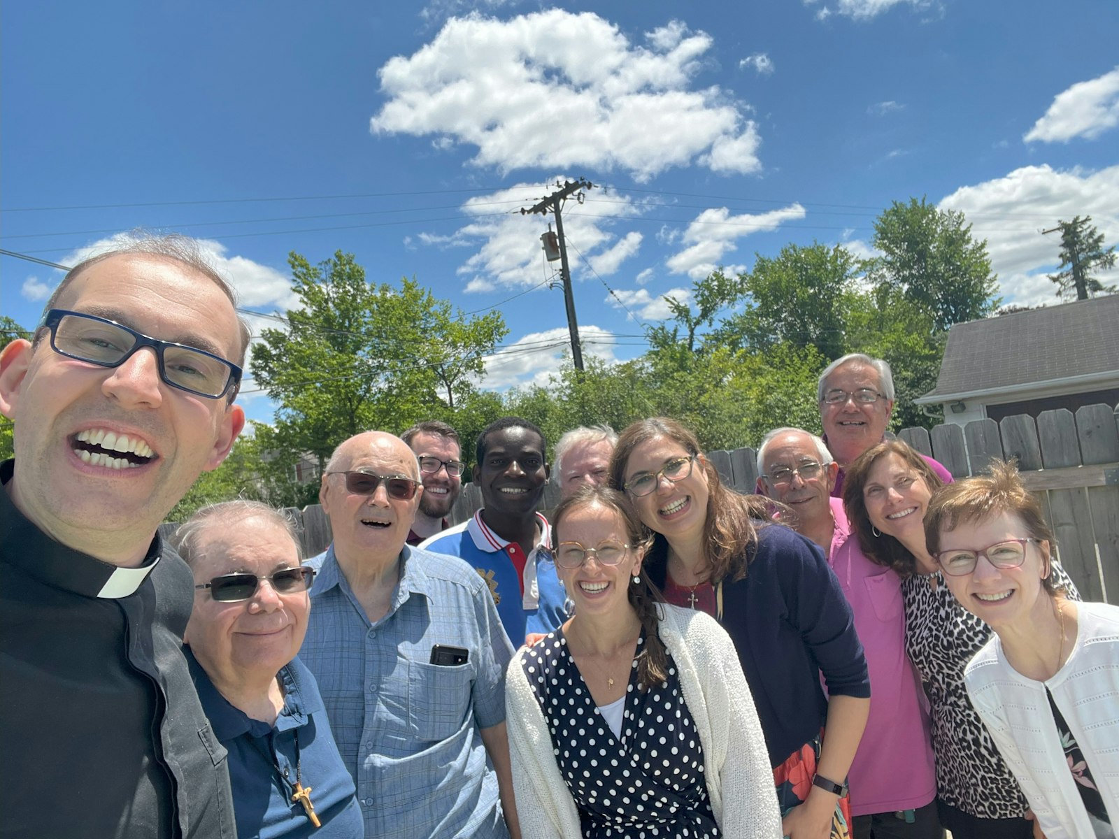 Fr. Daniele Criscione, PIME, left takes a "selfie" with the staff of the U.S. Mission Center in Farmington Hills. Fr. Criscione said the new location will allow PIME to better serve its priests, overseas missionaries and welcome donors to campus, showcasing how PIME helps in countries around the world.