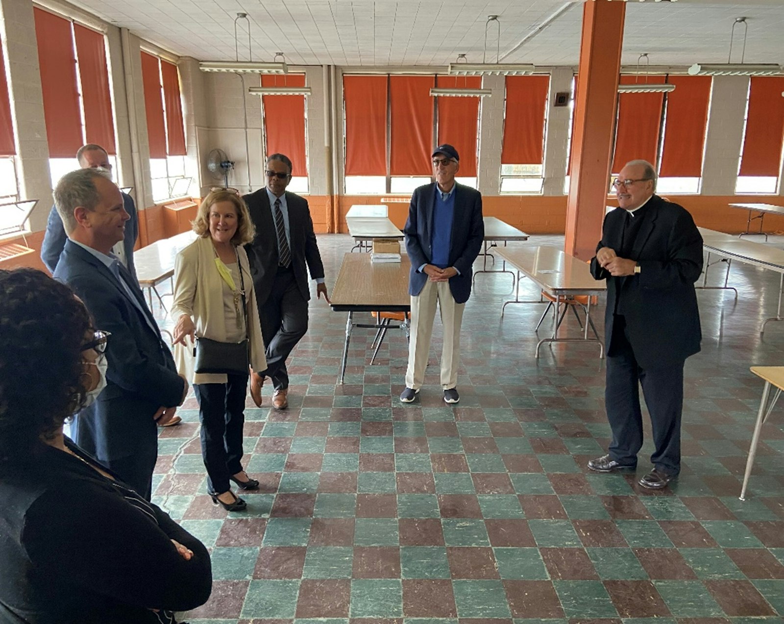 Fr. Duane Novelly, right, pastor of St. Matthew Parish in Detroit, gives Catholic Charities officials and other partners a tour of the former school building, which has been vacant since 2008. (Courtesy of St. Matthew Parish)