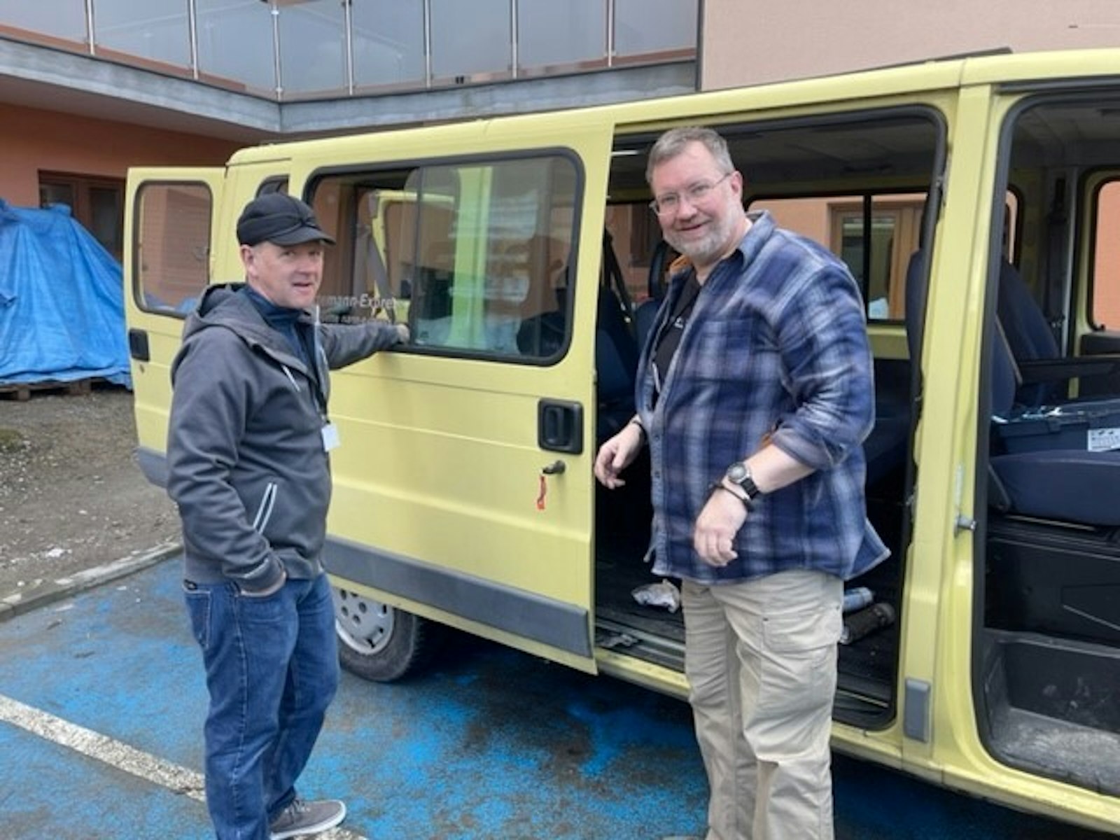 Volunteers from St. Clare of Montefalco Parish work on one of the two vans Fr. Machala's team uses to transport refugees from processing centers to more permanent locations, such as retreat centers, convents, hotels and peoples' homes. (Photo courtesy of St. Clare of Montefalco Parish)