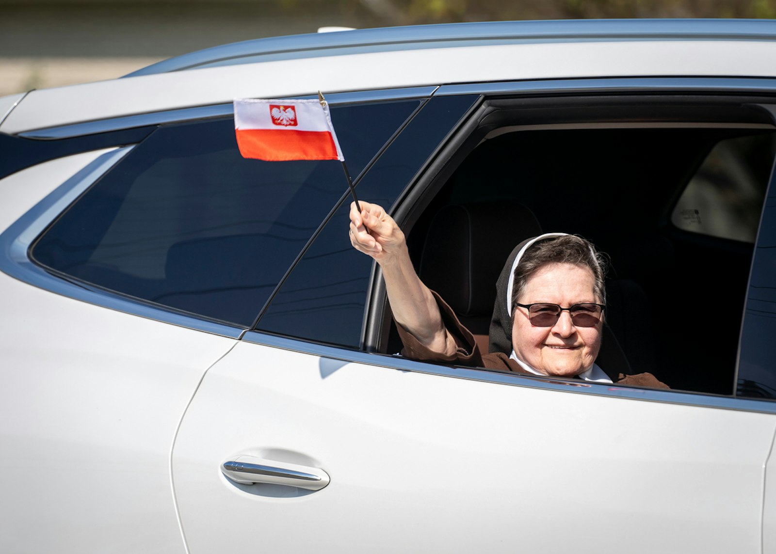 A Felician nun waves a Polish flag out the window of a car during the Polish Day Parade. The Felician Sisters arrived to North America from Poland 150 years ago and were honored at this year's parade.