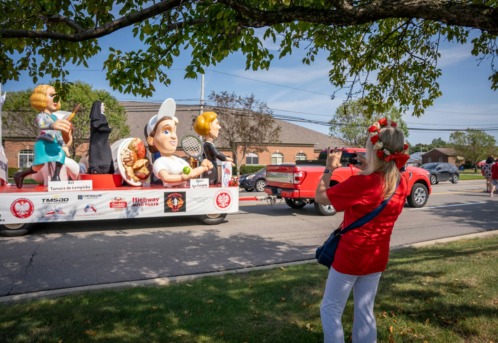 Spectators take pictures as a float honoring Polish women makes its way down Common Road.