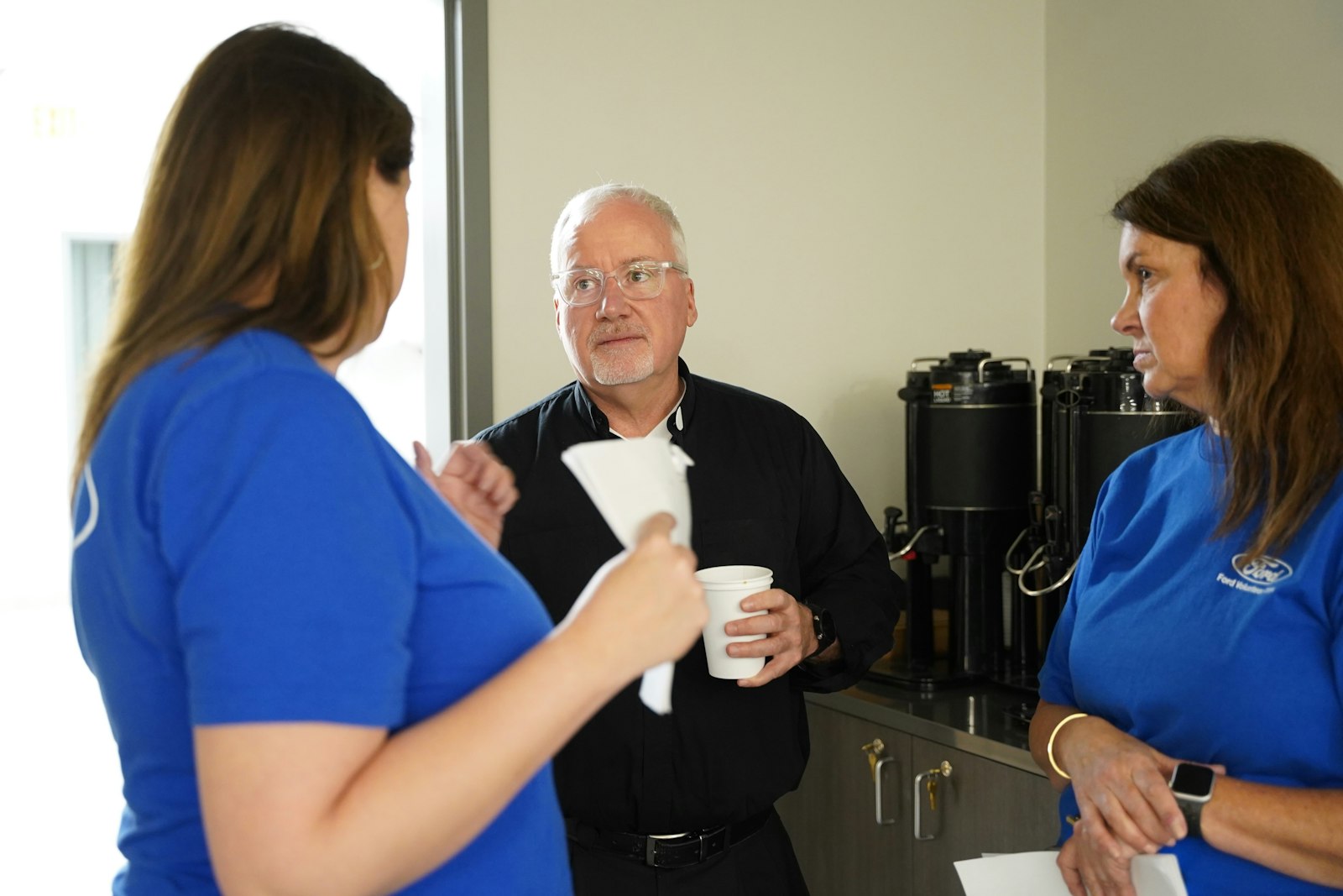 Fr. McCabe speaks with members of Ford Land at the Pope Francis Center's new bridge housing facility. Fr. McCabe went around the country, learning best practices for homeless ministry in order to apply those principles to the bridge housing facility.