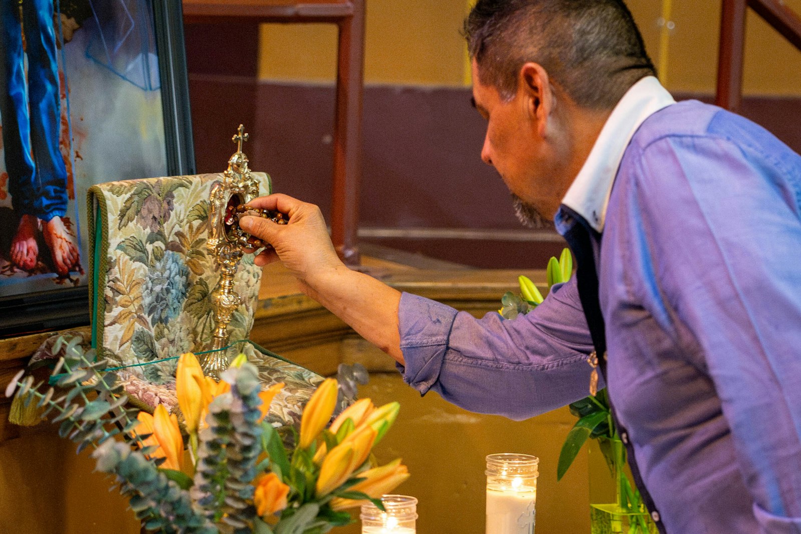 A man places a medal on the first-class relic of San José Sánchez del Río. (Photos by Steven Stechschulte | Detroit Catholic)
