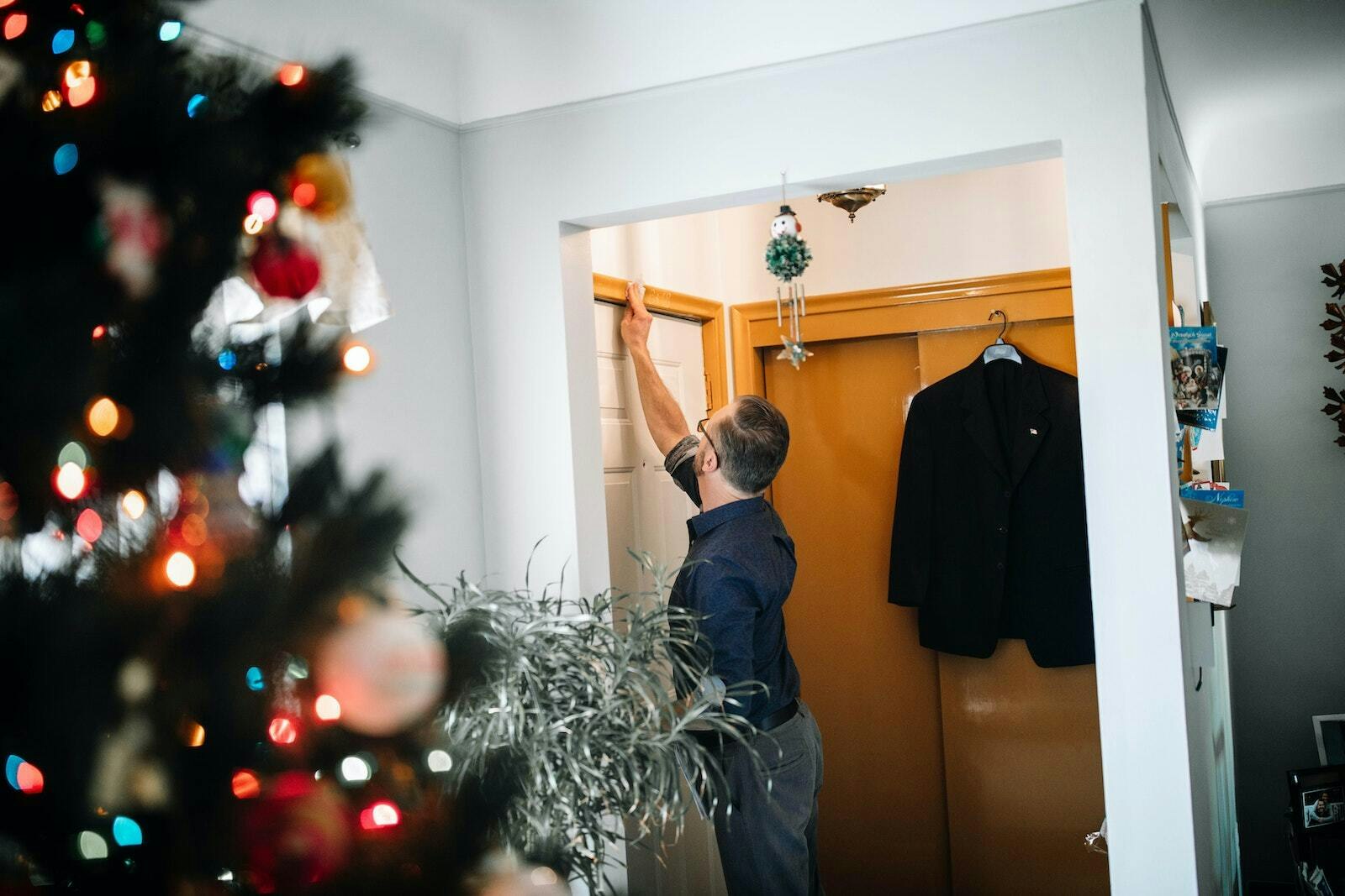 Mike Smigielski, miembro de la St. Hyacinth Parish en Detroit, marca la puerta de su hogar con tiza, una tradición que forma parte de la celebración de la Epifanía, que tiene lugar el 6 de enero. Las marcas, normalmente "20 + C + M + B + 24", son una forma que tienen los católicos de mostrar su devoción a Dios, pedirle que los bendiga en el año que comienza y rendir homenaje a los Reyes Magos que visitaron a Cristo en su primera casa. Mientras que las letras representan las iniciales de los tres Reyes Magos, los números indican el año. (Naomi Vrazo | Detroit Catholic)