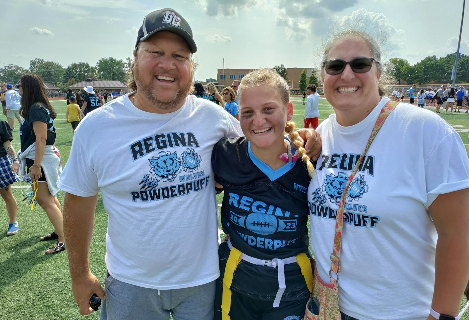 Savannah Weaver – flanked by her father Scott and mother Alison (Regina 1996) -- was punched in the face on the game’s first play, but she got the last laugh, Regina’s sixth straight powder puff victory against Marian. (Don Horkey | Special to Detroit Catholic)
