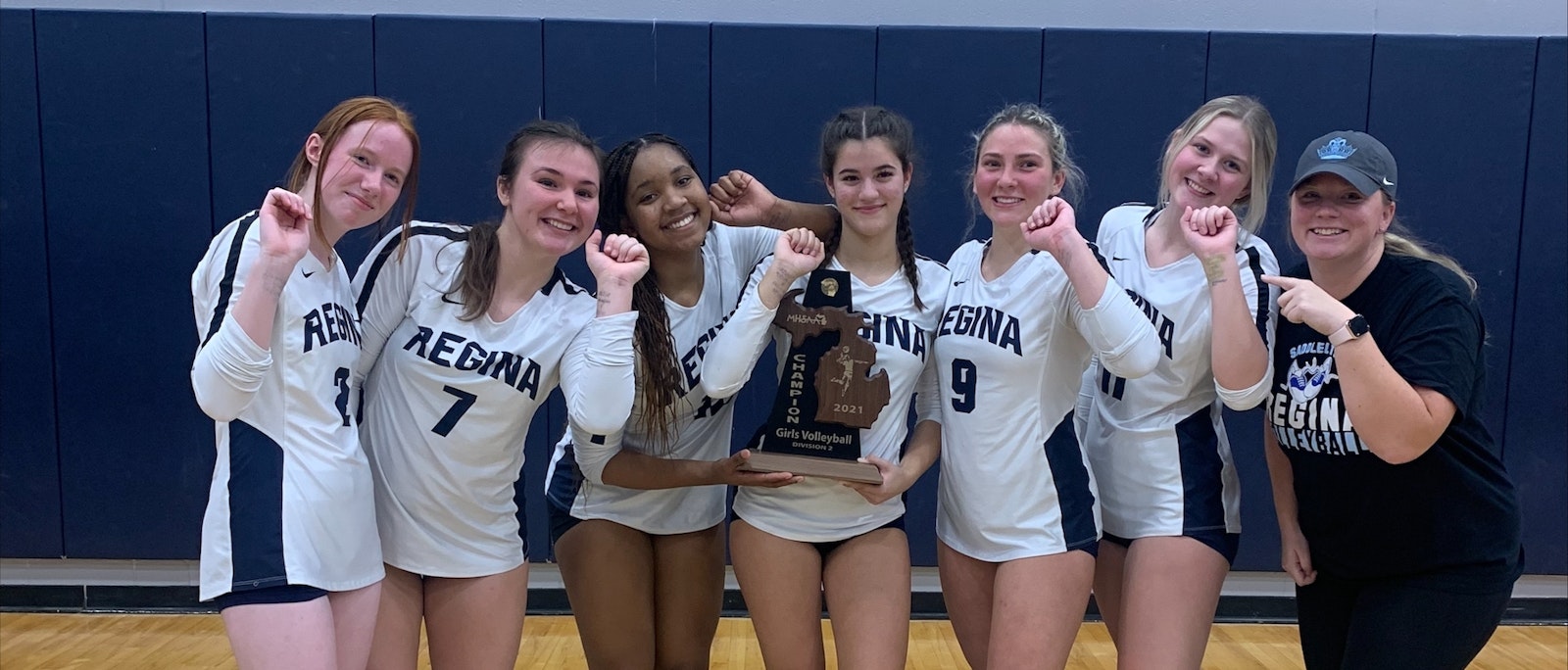 Members of Regina’s 2021 state district volleyball champions show off the mantra, "Positive thoughts equal positive results," written on their wrists. Incoming athletic director Emily Frikken, right, encouraged students to adopt the positive thinking motto to help them recognize the positive in everything.