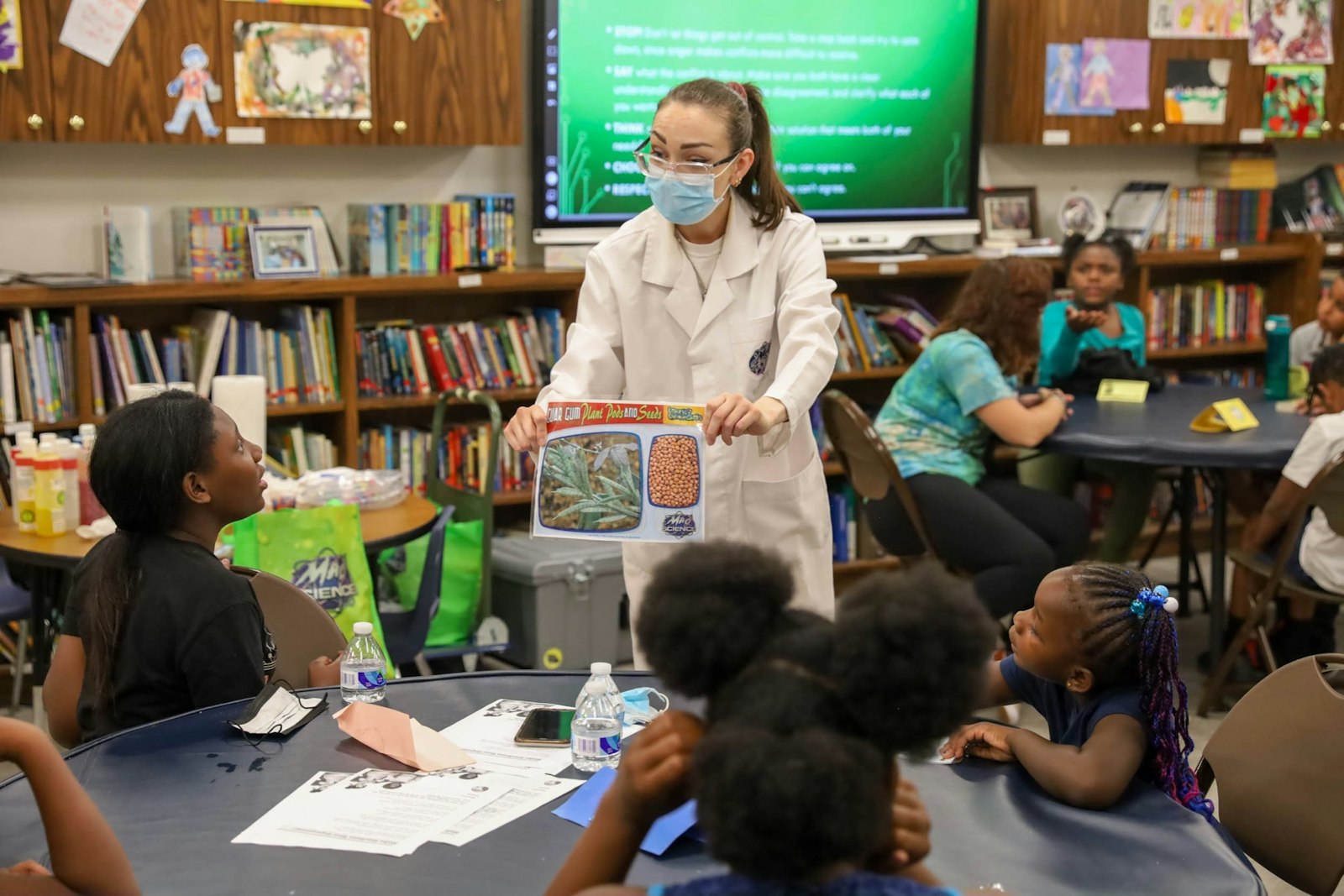 "Rocket Rachel," a teacher from Mad Science: Detroit, explains to campers about guar gum during an afternoon STEM (science, technology, engineering and math) learning session about how to make slime during the Rosa Parks Summer Peace Camp on July 28 at the Capuchin Soup Kitchen.