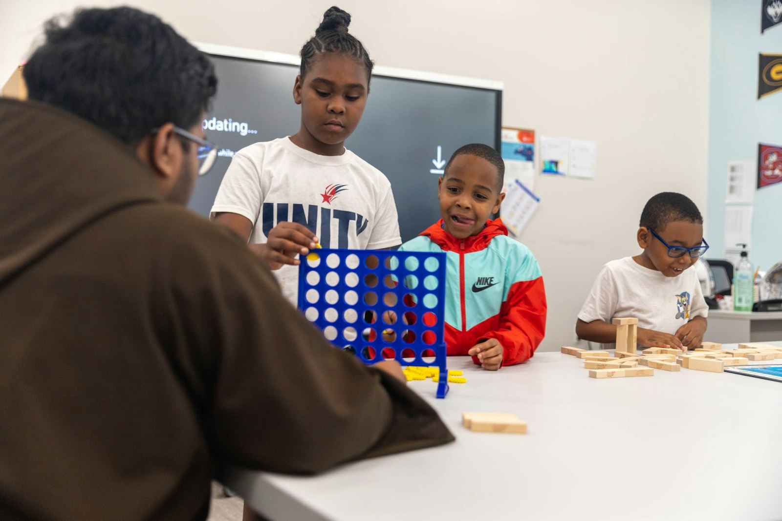 Bro. Shebin Philip, OFM Cap., accompanies campers during a friendly game of "Connect Four" during the Rosa Parks Summer Peace Camp at the Capuchin Soup Kitchen. The camp has been offering kids a chance for adventure and learning each summer for the past 24 years.