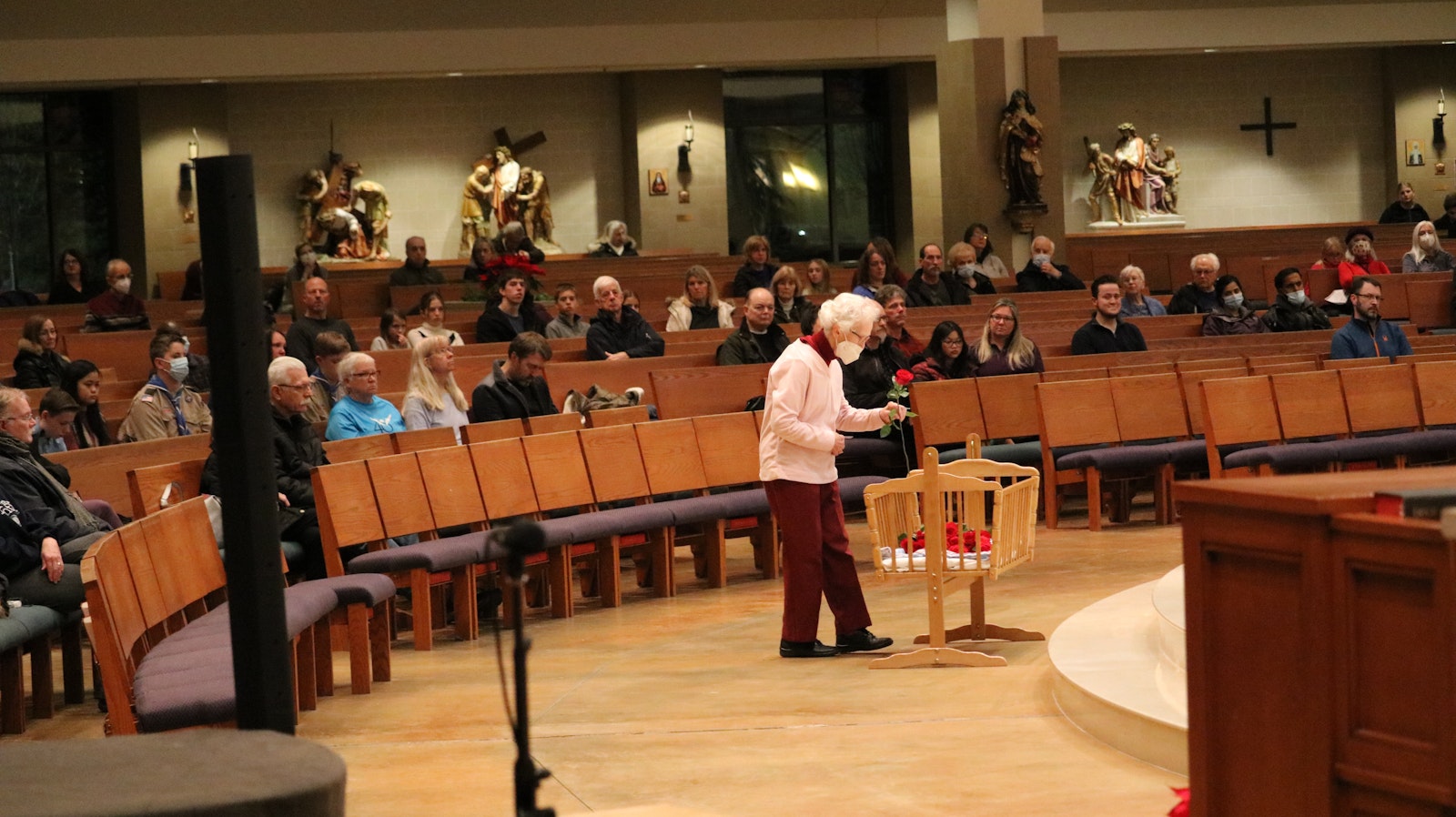 A woman places a rose in a basket at Our Lady of Good Counsel Parish in Plymouth on Jan. 19 during the parish's annual Rose Mass, which memorializes the lives lost since the Roe v. Wade Supreme Court decision. The parish has hosted the Mass for approximately 15 years. (Kathleen Wilson | Special to Detroit Catholic)