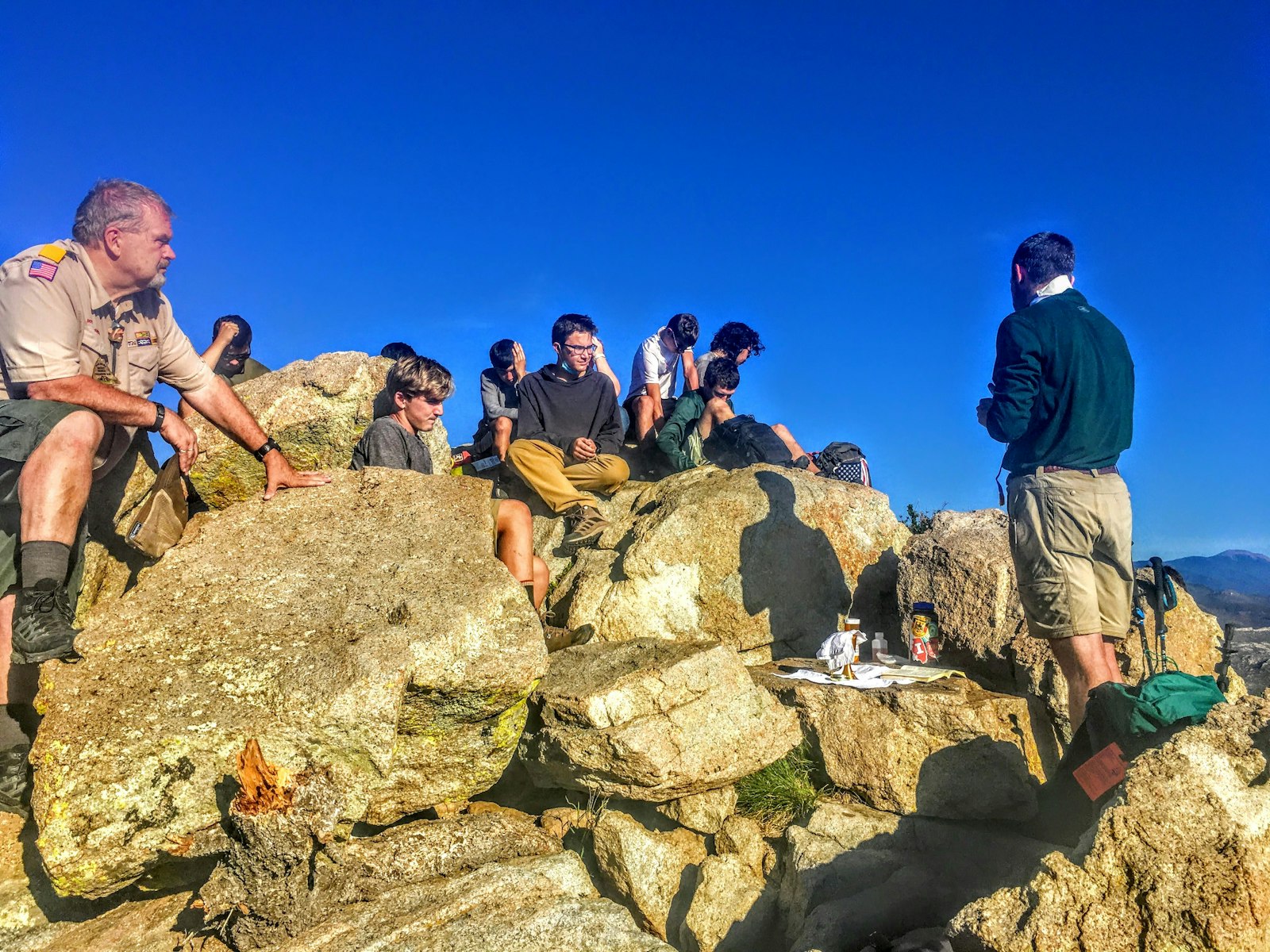 Después de despertarse a las 3 de la mañana para subir a la cima del Diente del Tiempo en el Rancho Scout Philmont de Nuevo México, los participantes en la Caminata de San Jorge celebran juntos la misa.