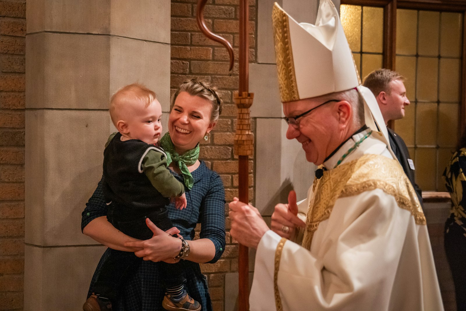 Detroit Auxiliary Bishop Jeffrey M. Monforton smiles at a baby at the 14th annual Dinner for Life at Sacred Heart Major Seminary. Bishop Monforton was rector at the seminary when the first Dinner for Life was organized in 2006.