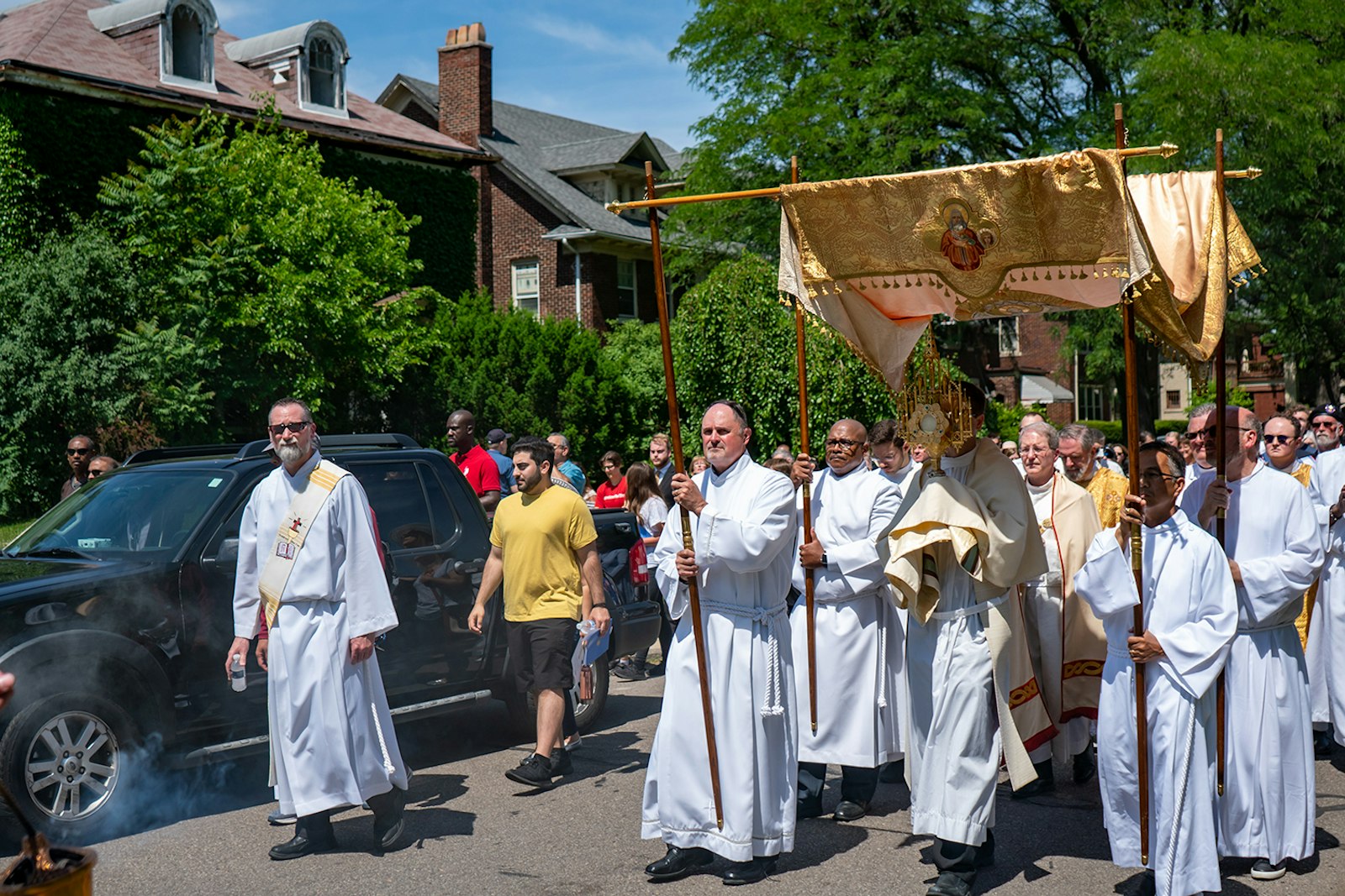 Una procesión eucarística pasa por las casas del distrito de Boston-Edison, en el noroeste de Detroit, durante la fiesta del Corpus Christi. Los transeúntes se arrodillaron en adoración al paso de Jesús en la Eucaristía, y los propietarios de las casas permanecieron en sus jardines delanteros asombrados. (Matthew Rich | Especial para Detroit Catholic)