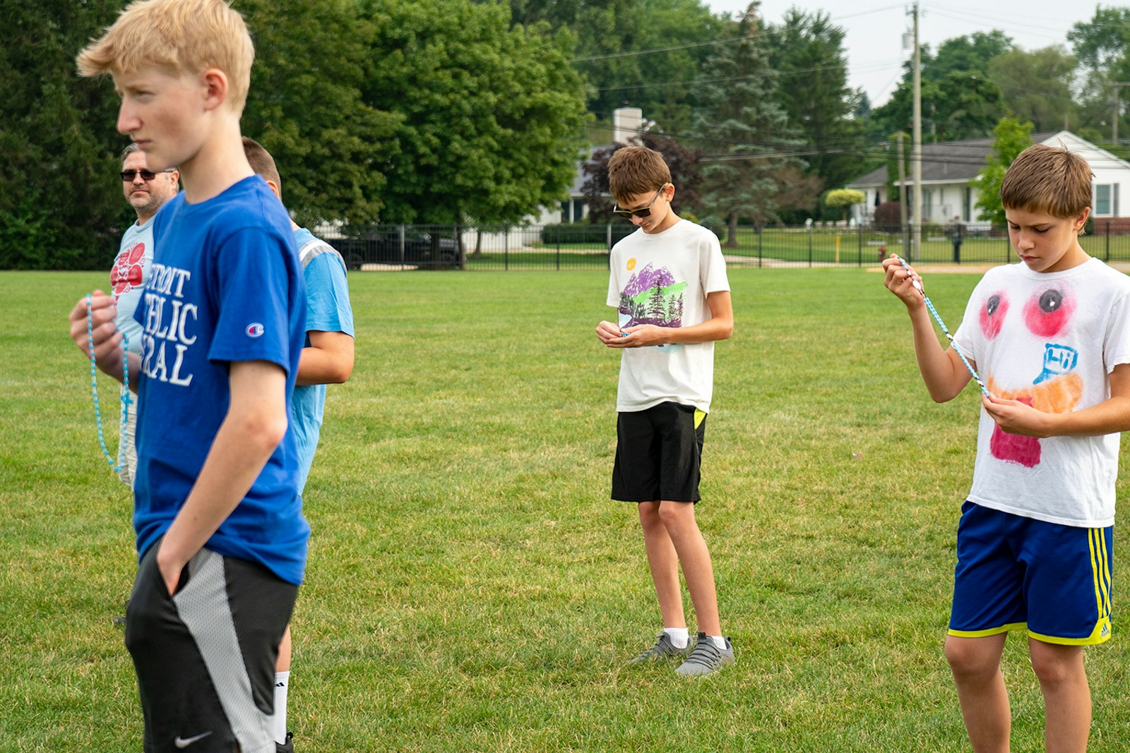 Members of the "Exercitus Mariae" group pray the rosary as they prepare for workouts Aug. 20. Often, boys attend the meetings with their fathers, sharing what they've learned about their faith.