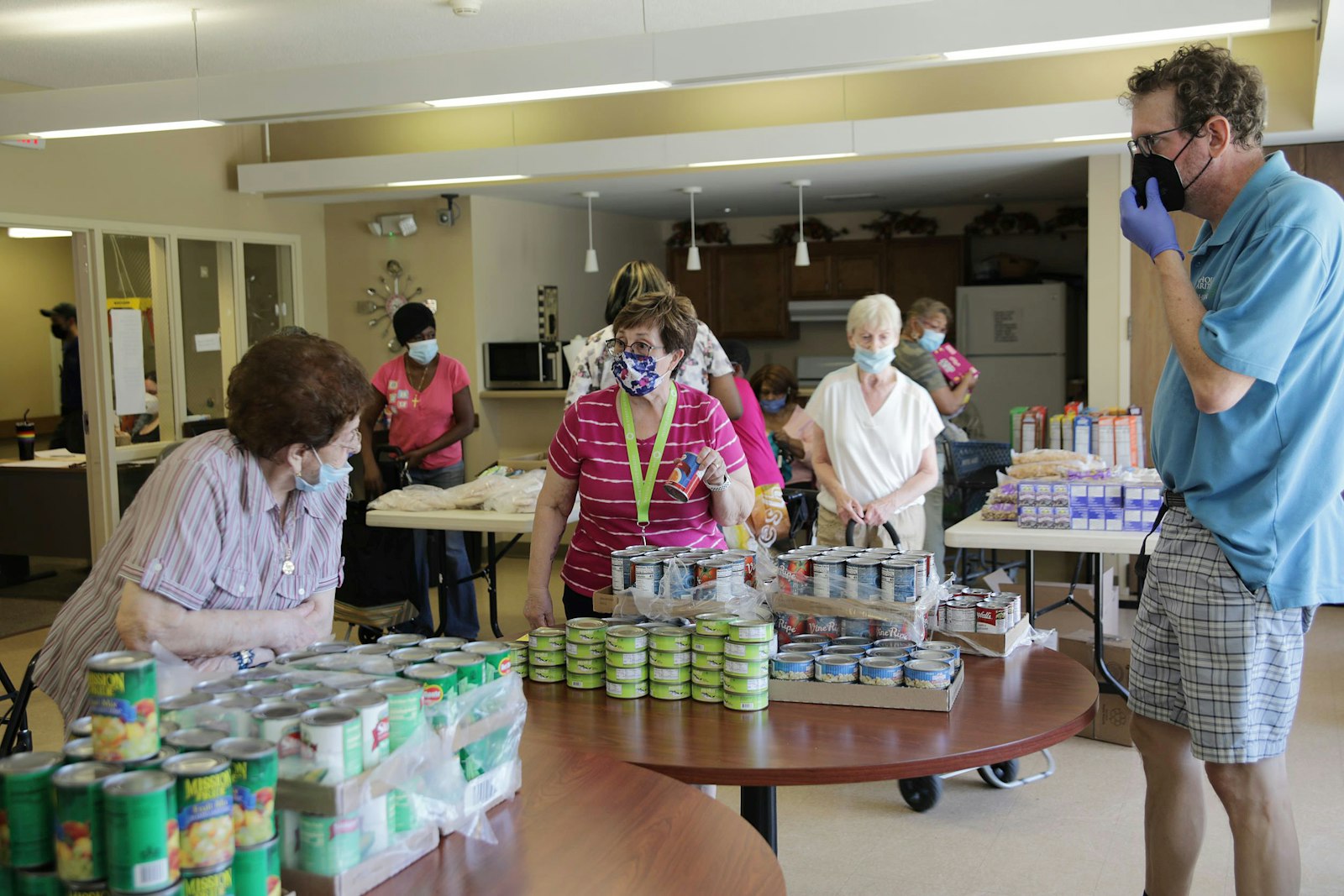 Mark Johnson, manager for program initiatives at Catholic Charities of Southeast Michigan, organizes volunteers in setting up a “pop-up pantry” at the Tivoli Manor Co-Apartments in Warren, where seniors can pick out food they need in a way that resembles a grocery store.