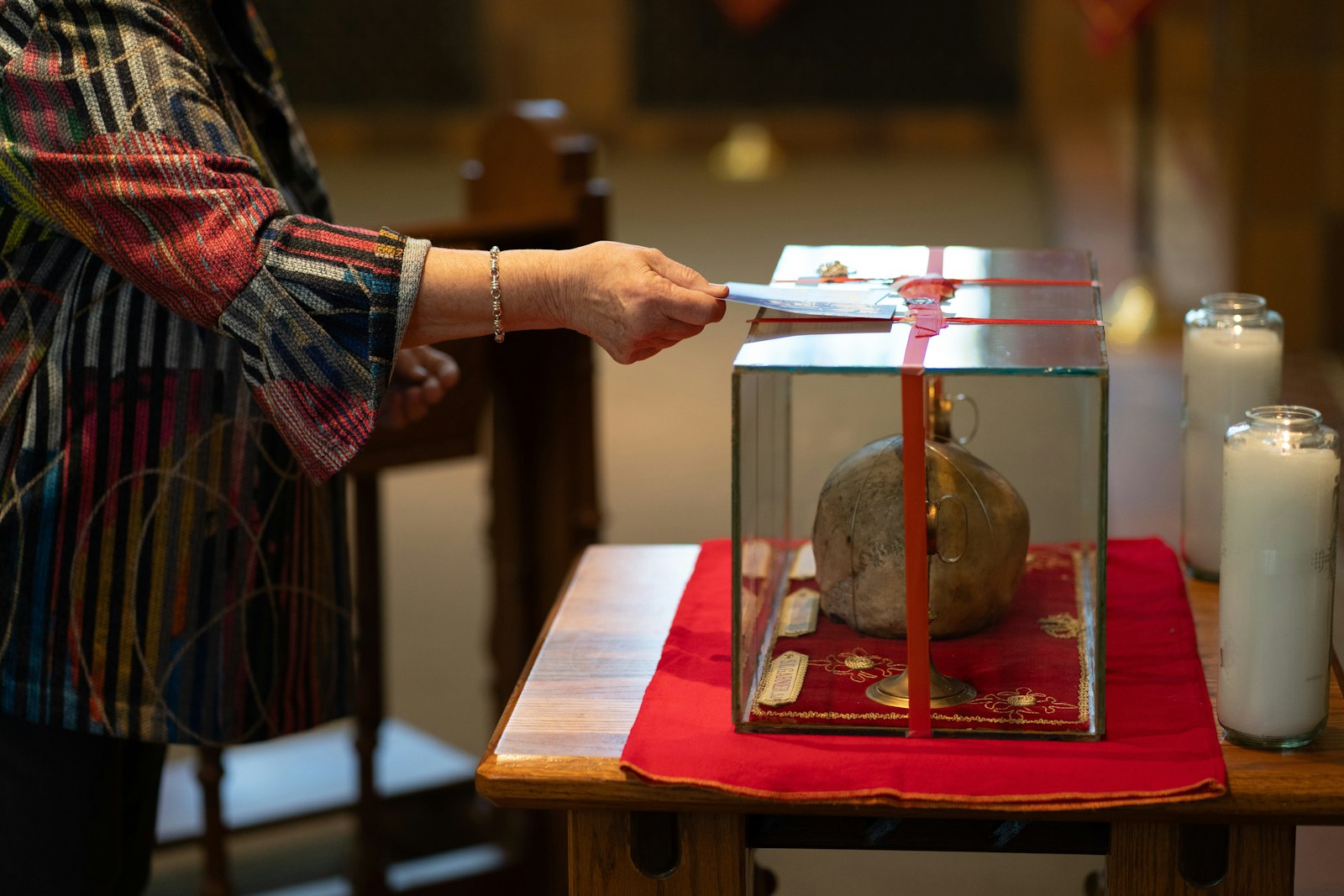 The faithful placed holy cards, rosaries and personal items on the glass container which housed the relics of Sts. Jean de Brebeuf, Charles Garnier and Gabriel Lalemant.