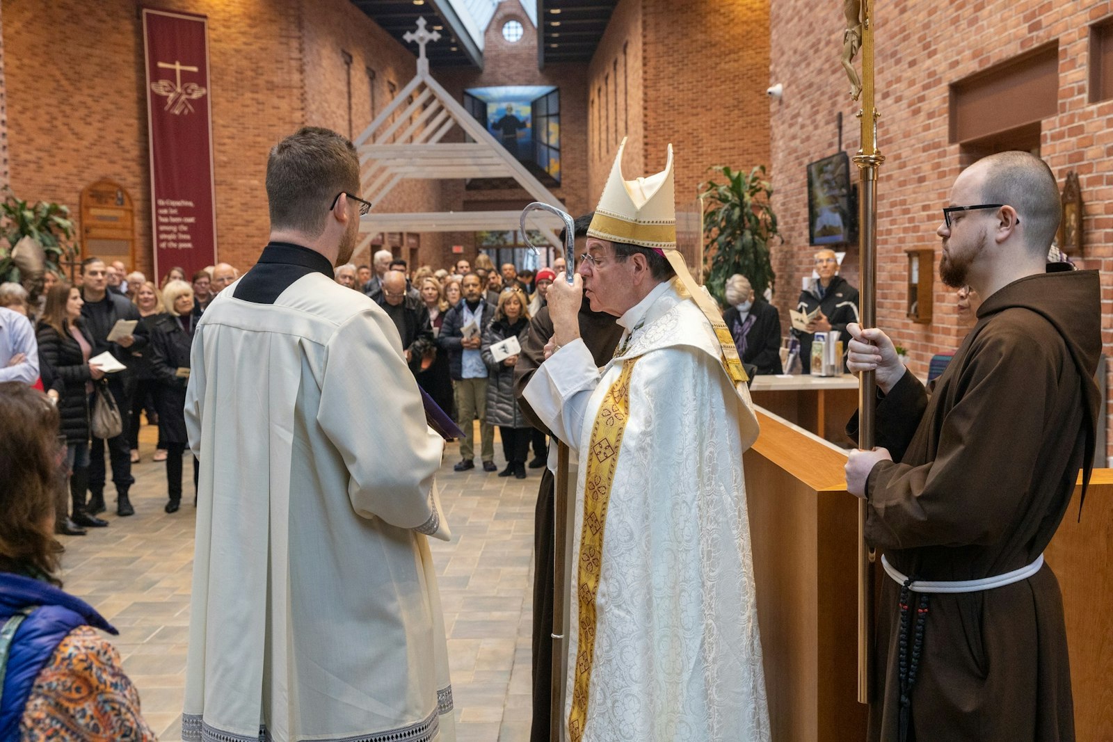 El arzobispo Vigneron realiza una oración de bendición en el mostrador de la recepción del recientemente renovado Solanus Casey Center en Detroit durante el 3 de diciembre. El arzobispo se unió a la Provincia Franciscana Capuchina de St. Joseph para dedicar una nueva expansión de 5,000 pies cuadrados, además de las renovaciones a las instalaciones existentes del centro.