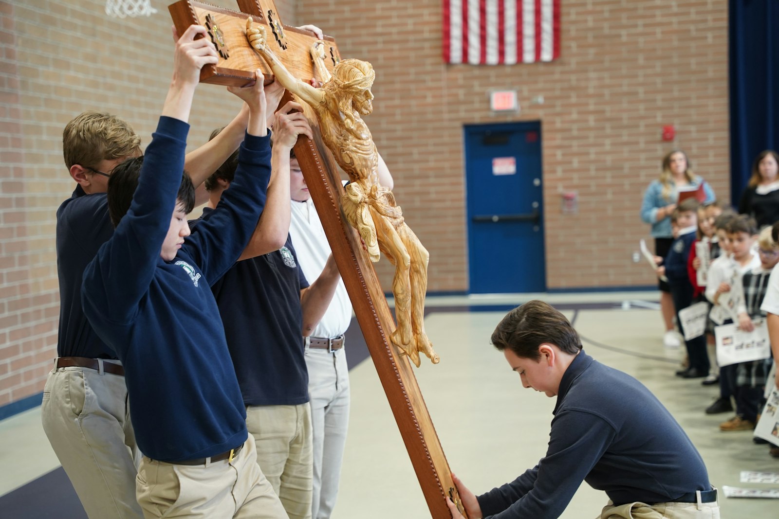 St. Mary School students stand the crucifix up in the school gymnasium, where students observed the Stations of the Cross. The original plan, to process from the school to nearby St. Peter Parish, was scuttled because of a weather forecast that included severe thunderstorms and a tornado watch.