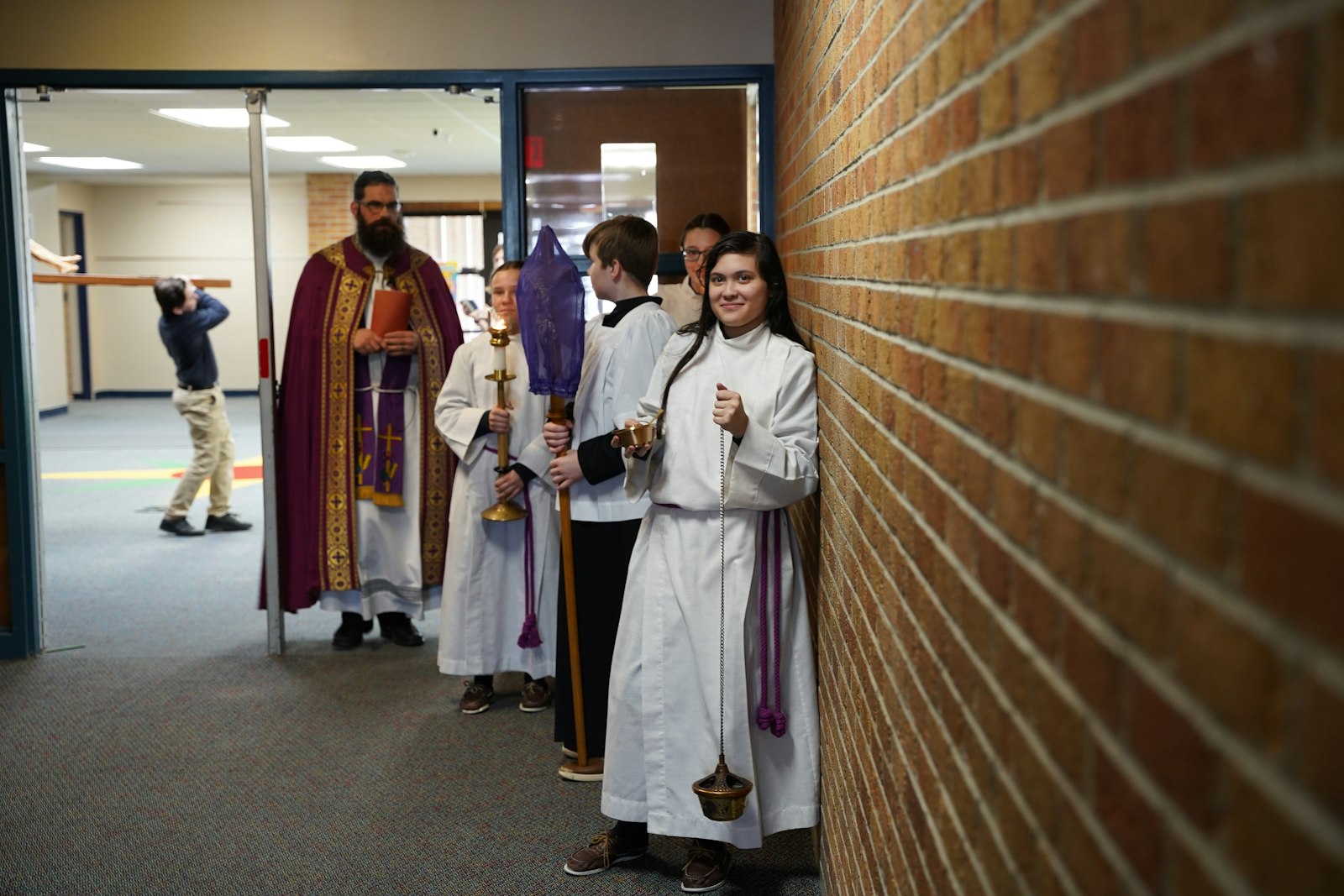 Fr. Christopher Muer leads a procession with an olive wood crucifix with students at St. Mary School in Mount Clemens.