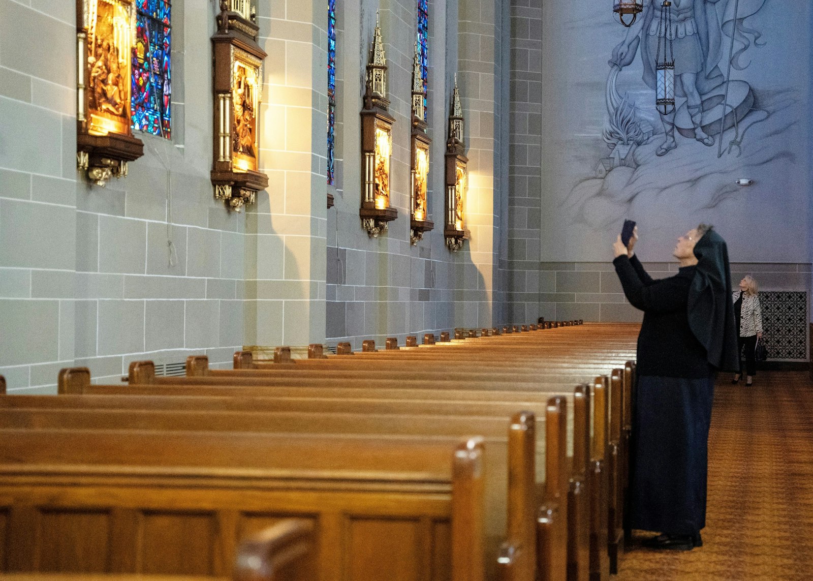 Sr. Esther Mary Nickel, RSM, director of sacred worship for the Archdiocese of Detroit, snaps a photo of the Stations of the Cross inside St. Florian Church in Hamtramck.