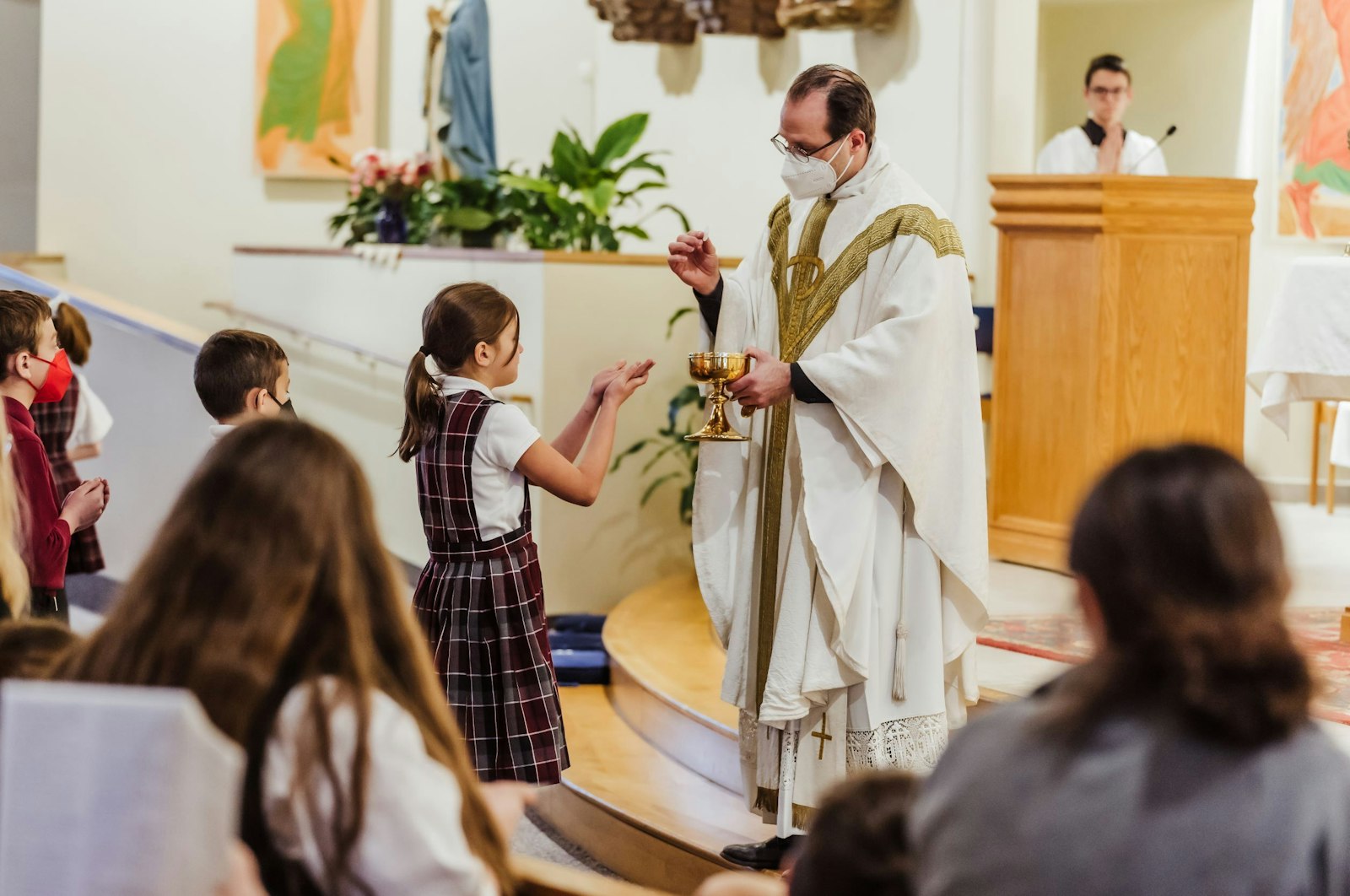 El Padre David Cybulski, párroco de la Parroquia de St. Isaac Jogues en St. Clair Shores, distribuye la Comunión durante una Misa escolar. Al menos 12 familias vinculadas a la escuela St. Isaac Jogues, que tiene una población estudiantil de 220, entrarán en la Iglesia Católica esta Pascua.