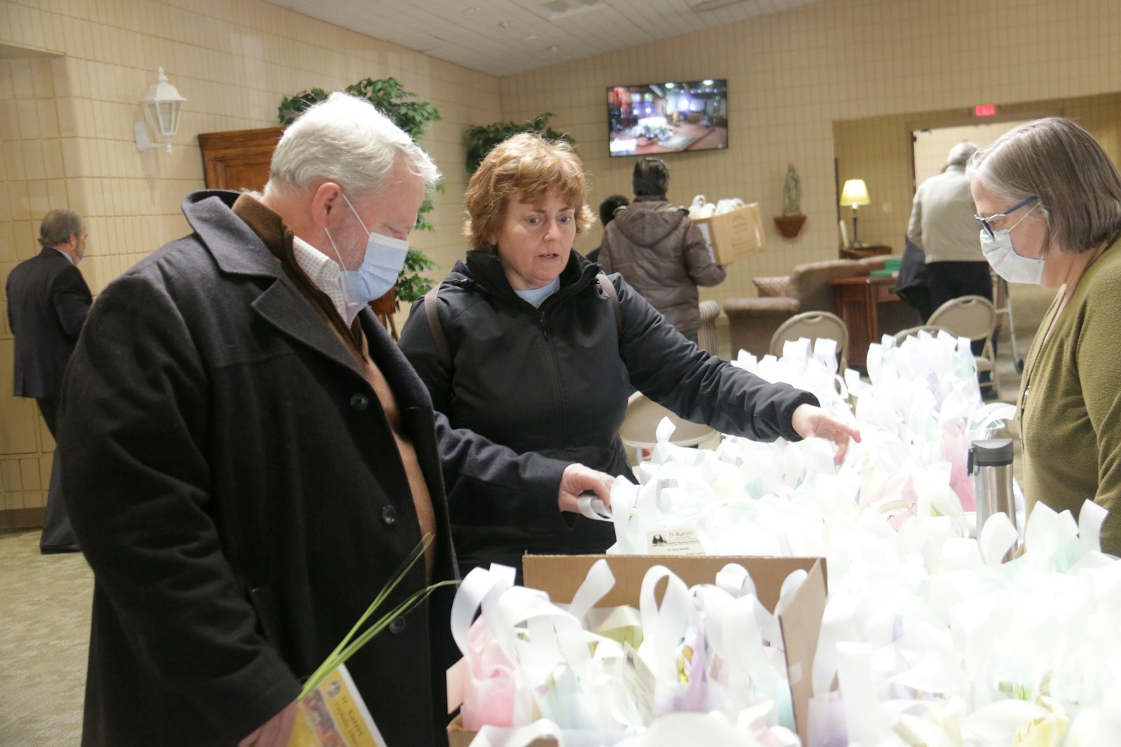 Los feligreses de Santa Kateri recogen bolsas de Pascua para entregarlas a los feligreses mayores después de la misa del Domingo de Ramos, el 10 de abril. La parroquia comenzó el programa de acercamiento durante la pandemia, pero decidió continuar para que los miembros mayores de la parroquia sepan que siguen siendo una parte valiosa de la comunidad parroquial.