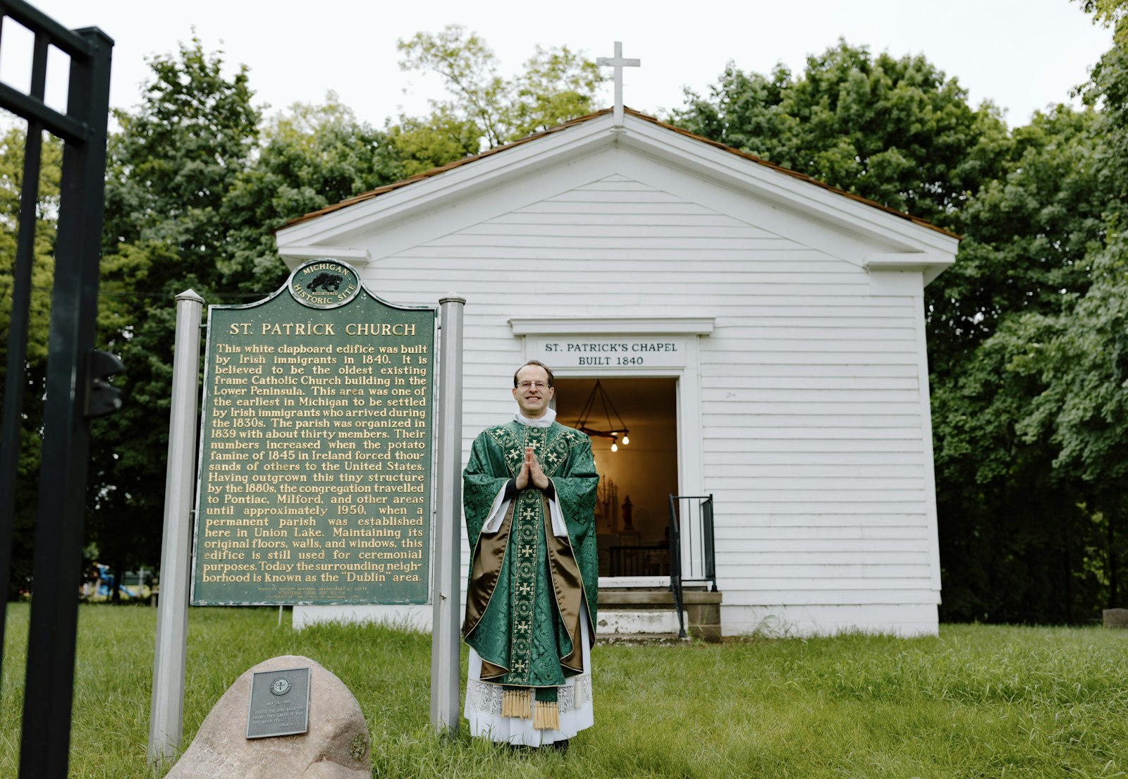 Fr. David Cybulski, moderator and priest in solidum at St. Patrick Parish, stands outside the historic 1840 chapel following Mass. For generations, priests at St. Patrick have cared for the humble historic site, the oldest Catholic structure in Michigan's Lower Peninsula.