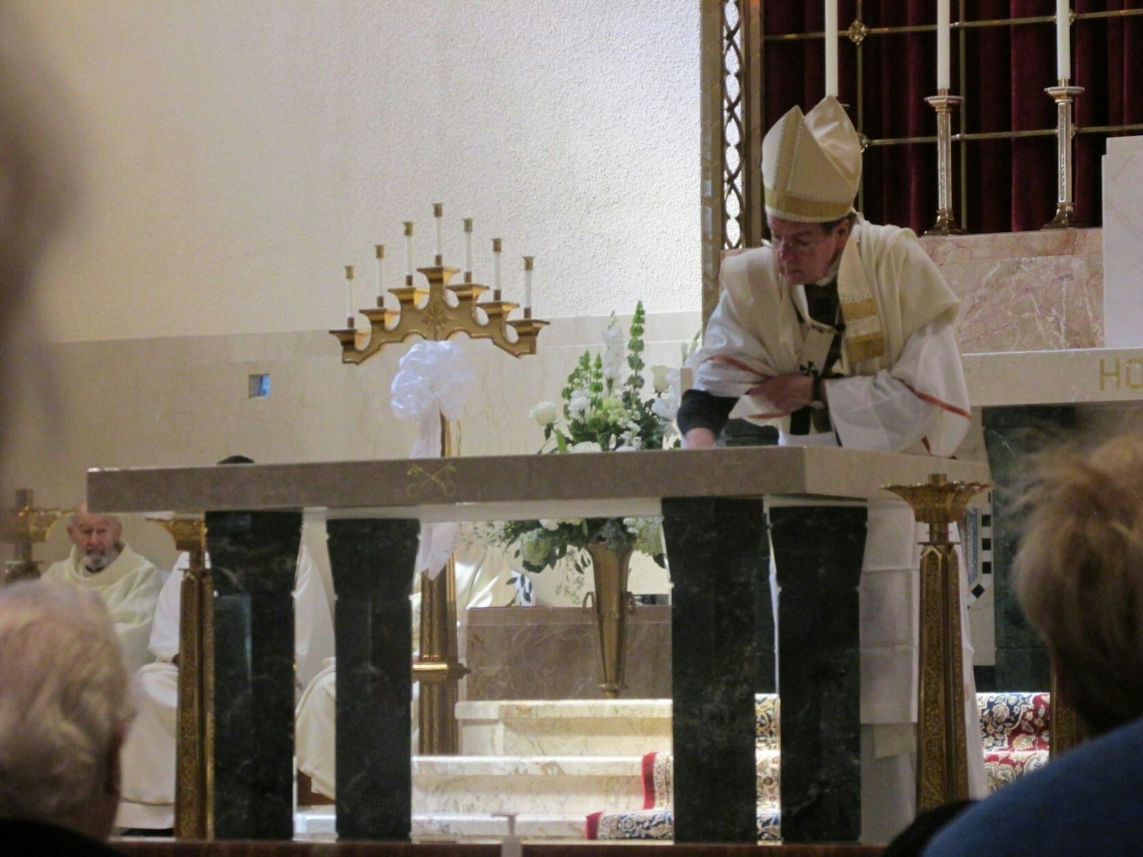 Archbishop Vigneron rubs chrism oil on the new altar at St. Peter Parish. The new altar contains relics of St. Thomas a’Becket and St. Elizabeth Anne Seton.