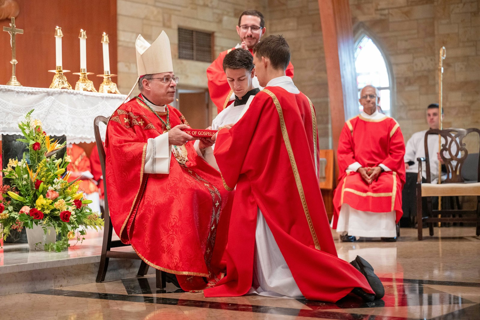 Archbishop Marcel Damphousse entrusts Deacon Sebastian Muggeridge with the book of the Gospels. Deacon Muggeridge, of Ottawa, Ontario, got his first call to religious life during a retreat hosted by the Companions of the Cross, where he had a profound experience in confession.