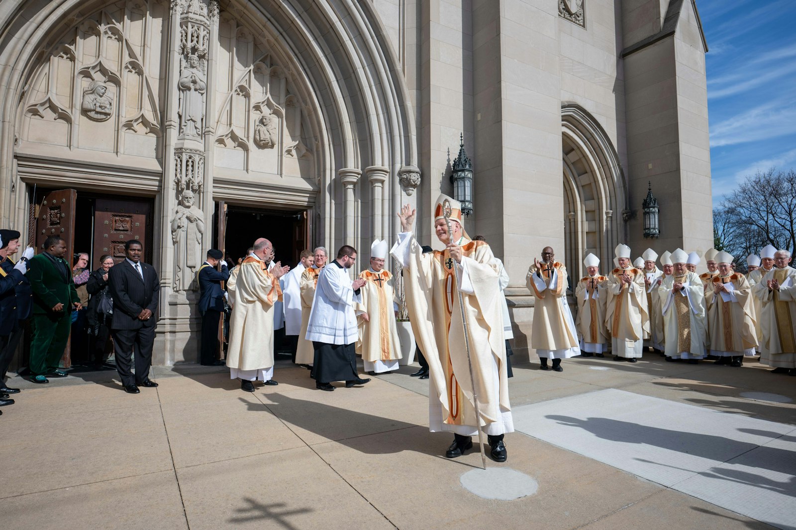 Archbishop Weisenburger waves to well-wishers, including a musical group from Missio Ad Gentes Detroit, which held a banner welcoming him to the Archdiocese of Detroit. (Tim Fuller | Special to Detroit Catholic)