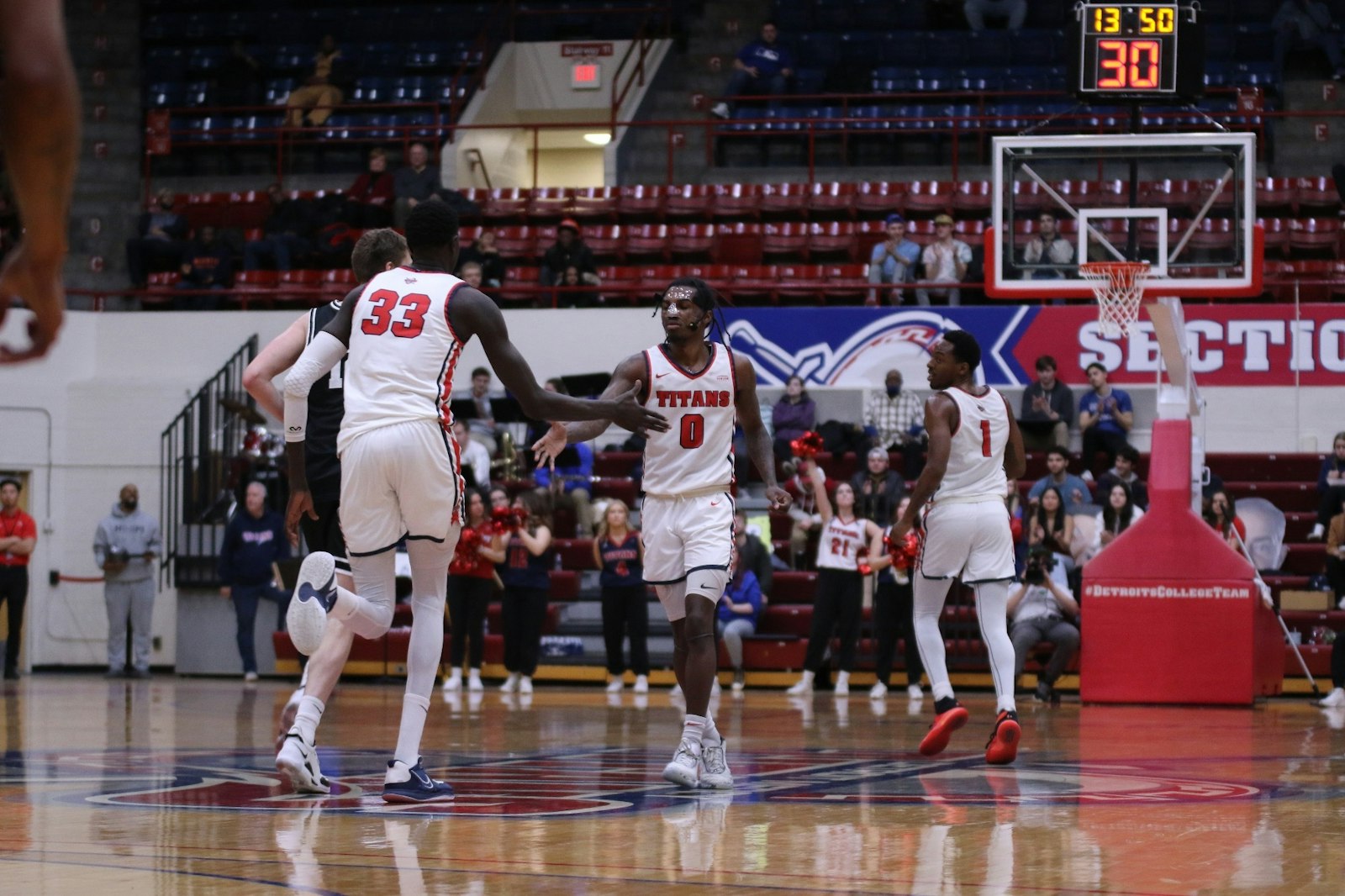 Detroit Mercy’s Buay Koka (33) congratulates guard Antoine Davis after he made another three-point shot on Feb. 25 at Calihan Hall. (Photo by Tamera Adderley | University of Detroit Mercy Sports Information Department)