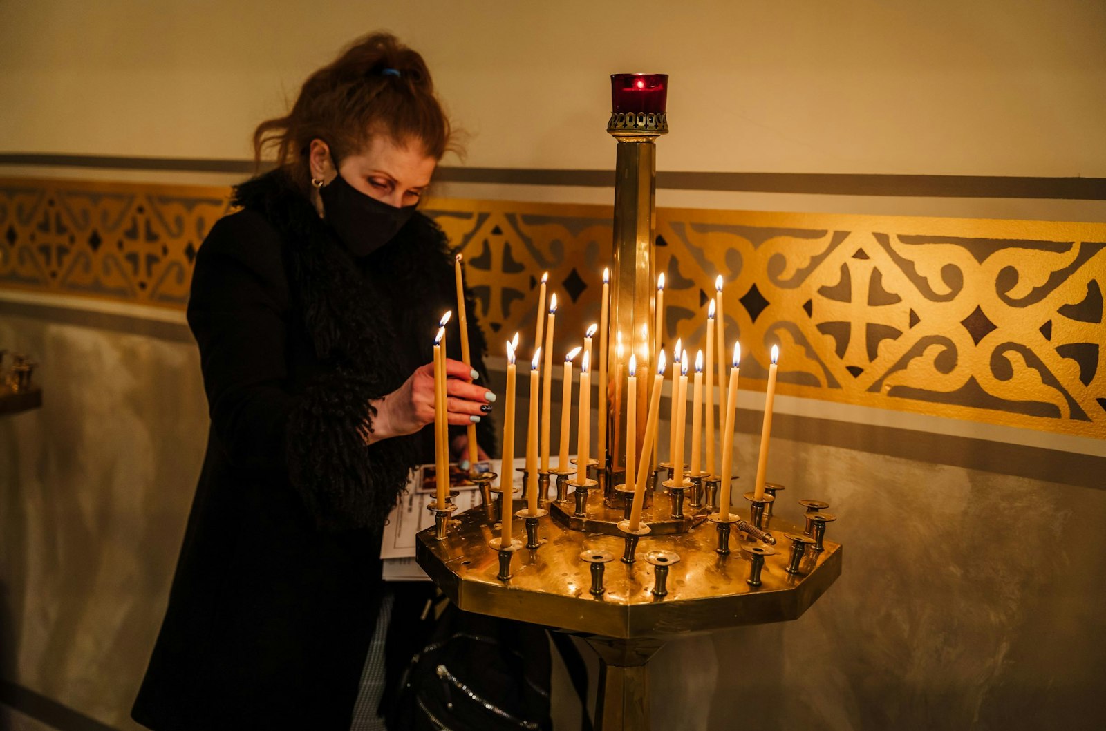 A woman lights votive candles at St. Mary the Protectress Ukrainian Orthodox Cathedral in Southfield on Feb. 5, where members of the local Ukrainian Catholic and Orthodox communities gathered to pray for a diffusion of tensions along the Russia-Ukraine border, where Russian forces have assembled en masse, threatening the security of its eastern European neighbor. (Valaurian Waller | Detroit Catholic)
