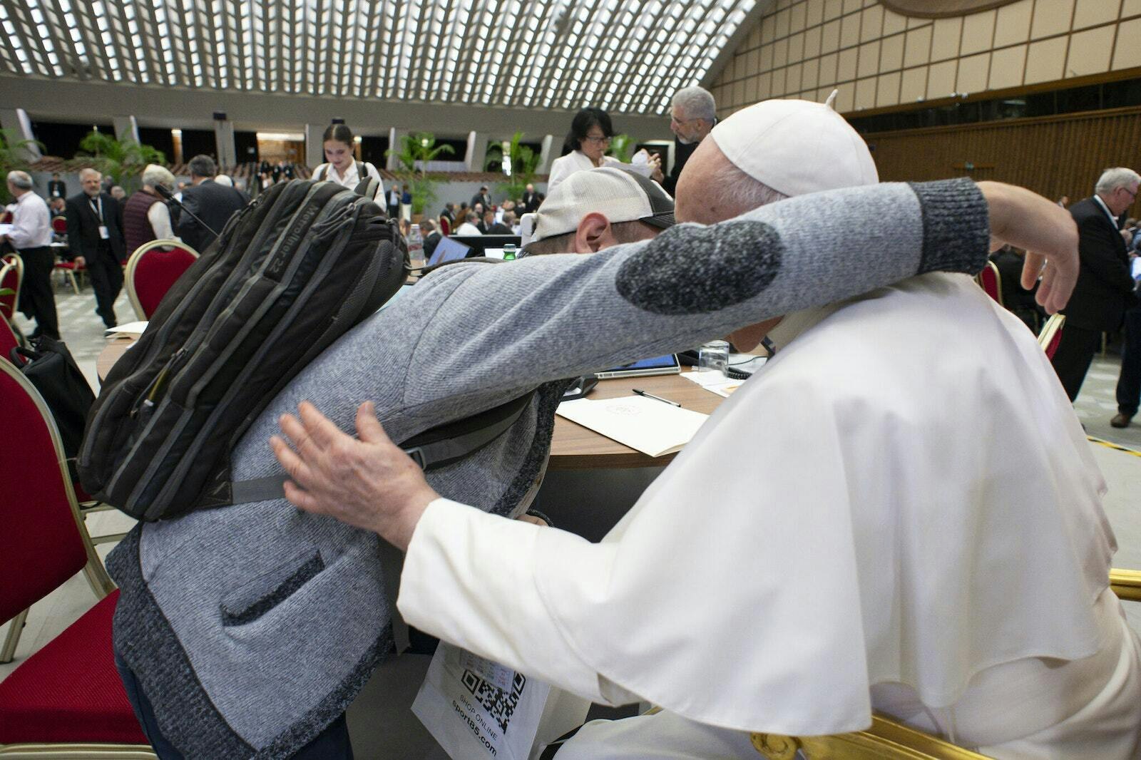 Urquidi gives Pope Francis a hug after the pope gave the 39-year-old father of three a bag of candies to take home to his children. Urquidi said the pope was "like a grandfather to my children" throughout the four-week synod general session, asking frequently about his family and even recording a short birthday greeting for Urquidi's daughter. (Photo by Vatican Media, courtesy of José Manuel de Urquidi)