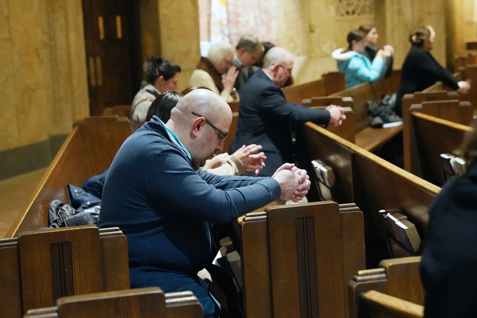 A man prays at the National Shrine of the Little Flower Basilica in Royal Oak during a Mass that marked the 51 years since the U.S. Supreme Court's Roe v. Wade decision, which legalized abortion nationally. That decision has since been overturned, but a constitutional referendum in 2022 placed abortion rights into Michigan's state constitution.