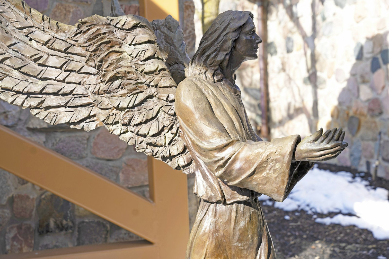 One of two bronze-cast, 5-foot-tall messenger angels created by Suzanne Young stands facing the altar through a window at St. Joseph the Worker Parish in Lake Orion. Young created the angels during the church's expansion in the 1990s. (Gabriella Patti | Detroit Catholic)