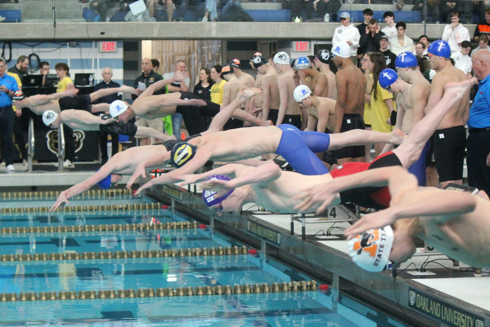 Camren Turowski (in the blue swim cap) is about to hit the water first on the opening leg of the 200 freestyle relay. Turowski and Catholic Central teammates Adyn Stoddard, Luke Mychalowych and Jack Szuba won the race.