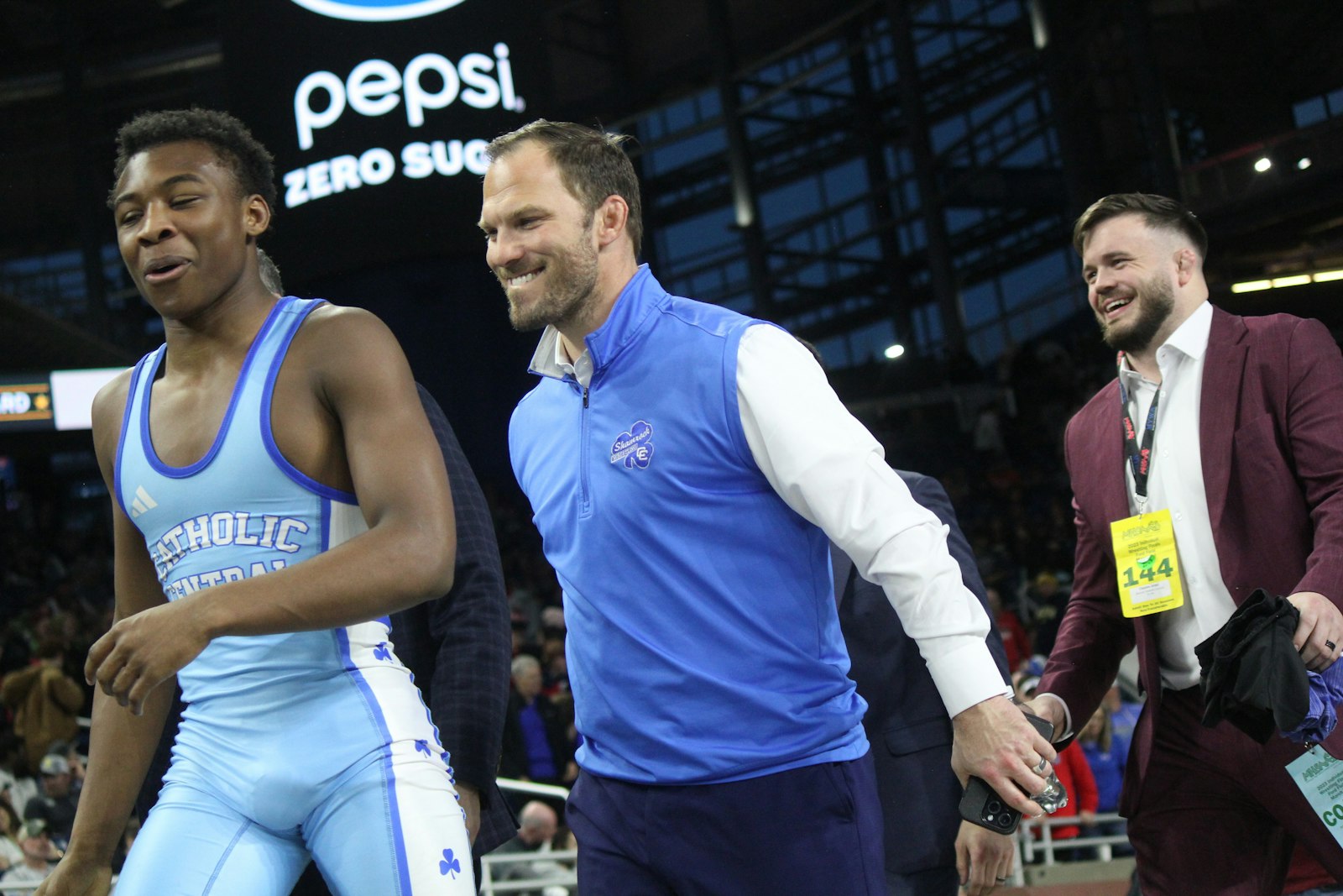 After the final match of the weekend, senior Clayton Jones leaves the mat with his second state championship, followed by head coach Mitch Hancock and assistant Kevin Beasley.
