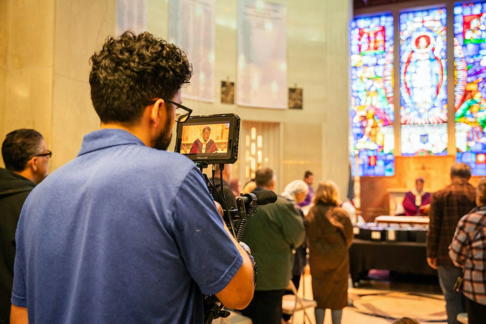 Un miembro de la productora de Famie, Visionalist Entertainment Productions, filma la Misa del Día de Todos los Santos para el próximo documental. (Valaurian Waller | Detroit Catholic)